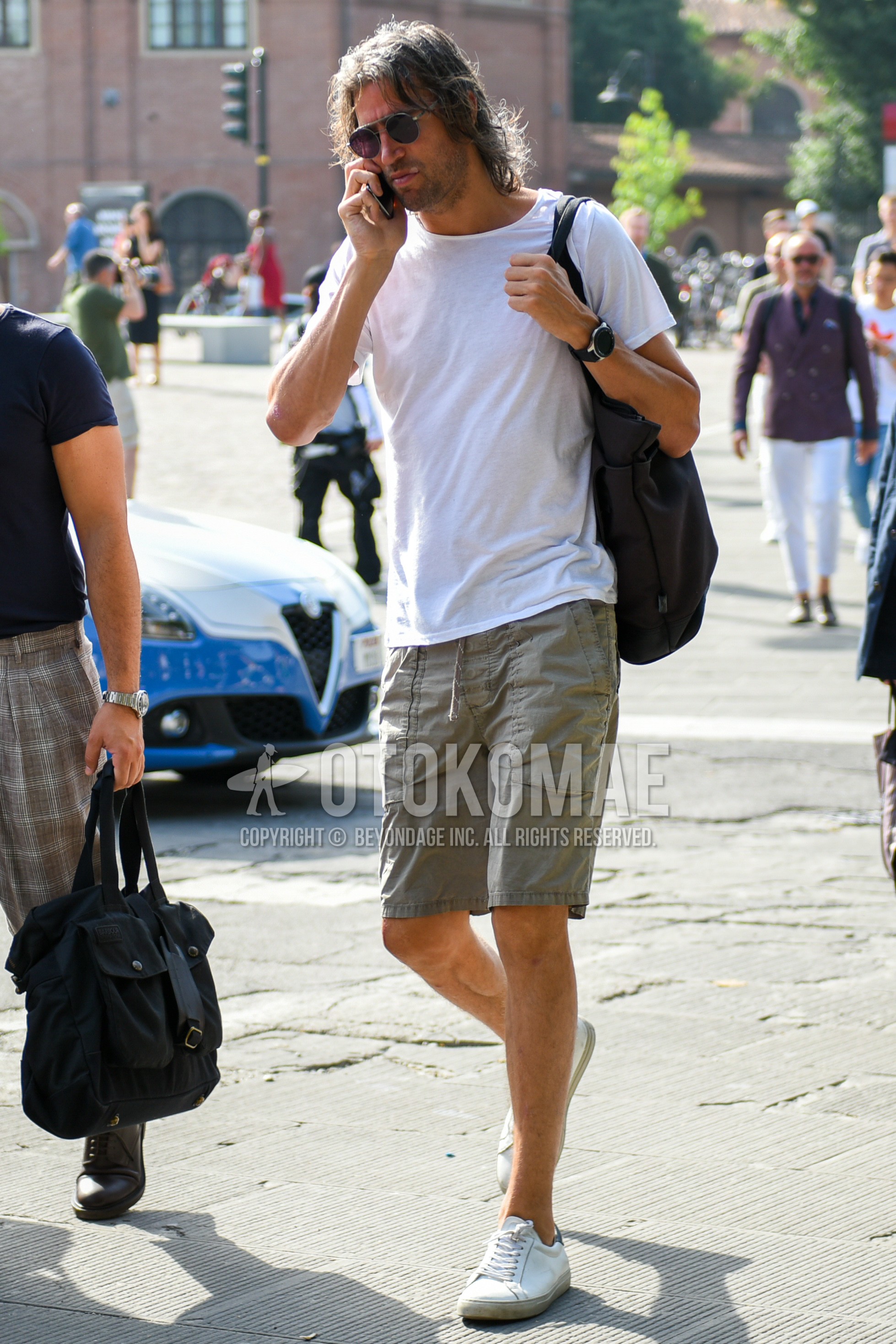 Men's summer outfit with gray plain sunglasses, white plain t-shirt, gray plain short pants, white low-cut sneakers.