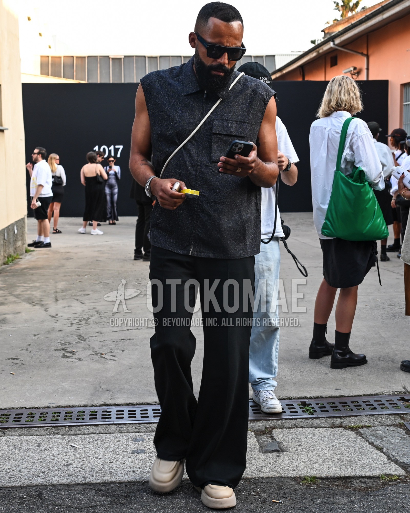 Men's spring summer outfit with black plain sunglasses, black plain casual vest, black plain wide pants, white low-cut sneakers.