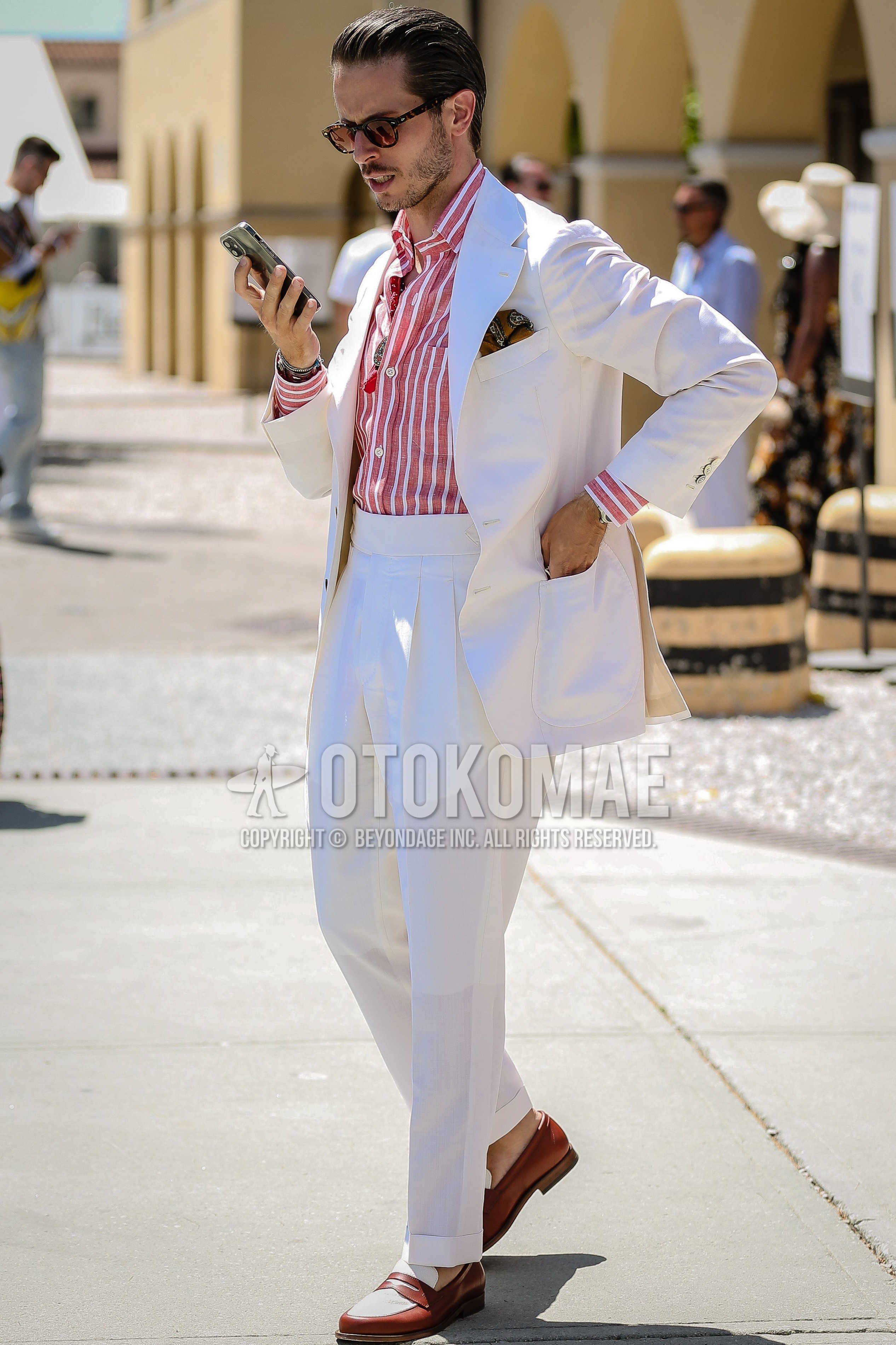Men's spring summer outfit with black plain sunglasses, red stripes shirt, brown coin loafers leather shoes, white plain suit.