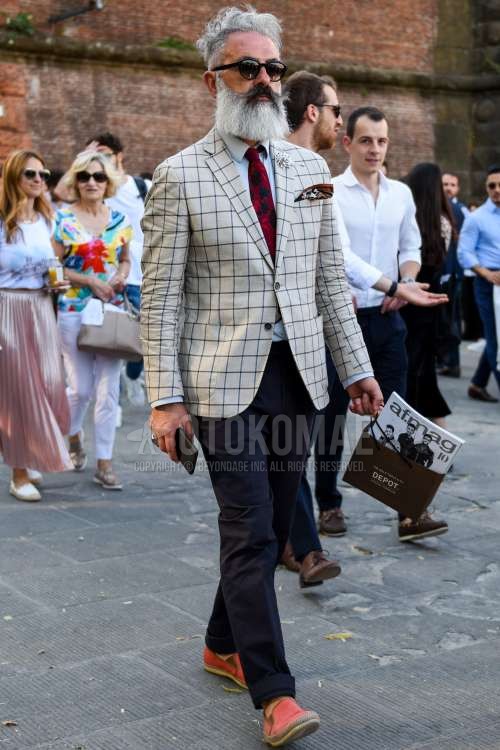 黒無地のサングラス、ベージュチェックのテーラードジャケット、白無地のシャツ、ダークグレー無地のスラックス、オレンジ無地のエスパドリーユ、レッドネクタイのネクタイを合わせた春秋のメンズコーデ・着こなし。