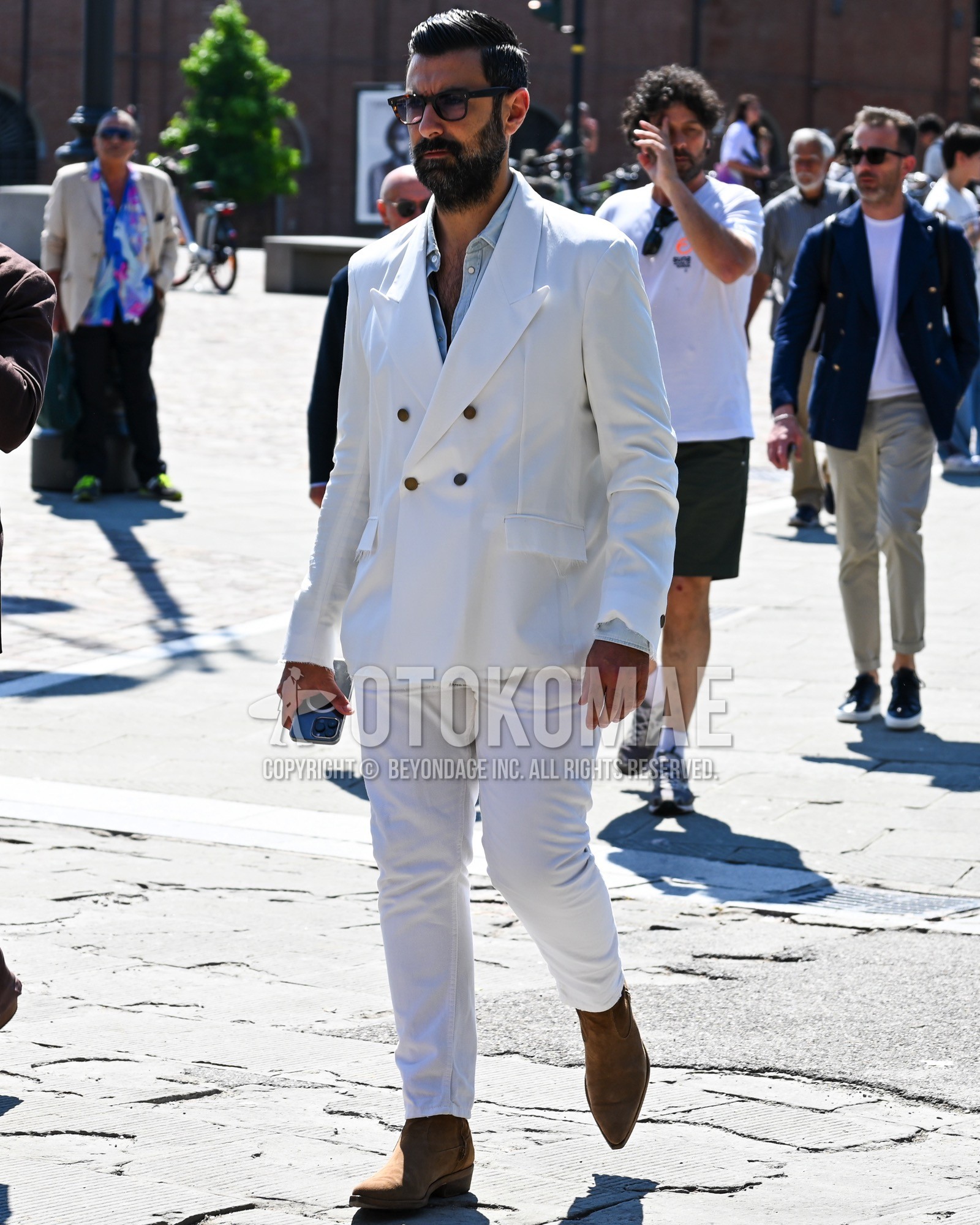 Men's spring summer autumn outfit with clear plain sunglasses, light blue plain shirt, beige  boots, white plain suit.