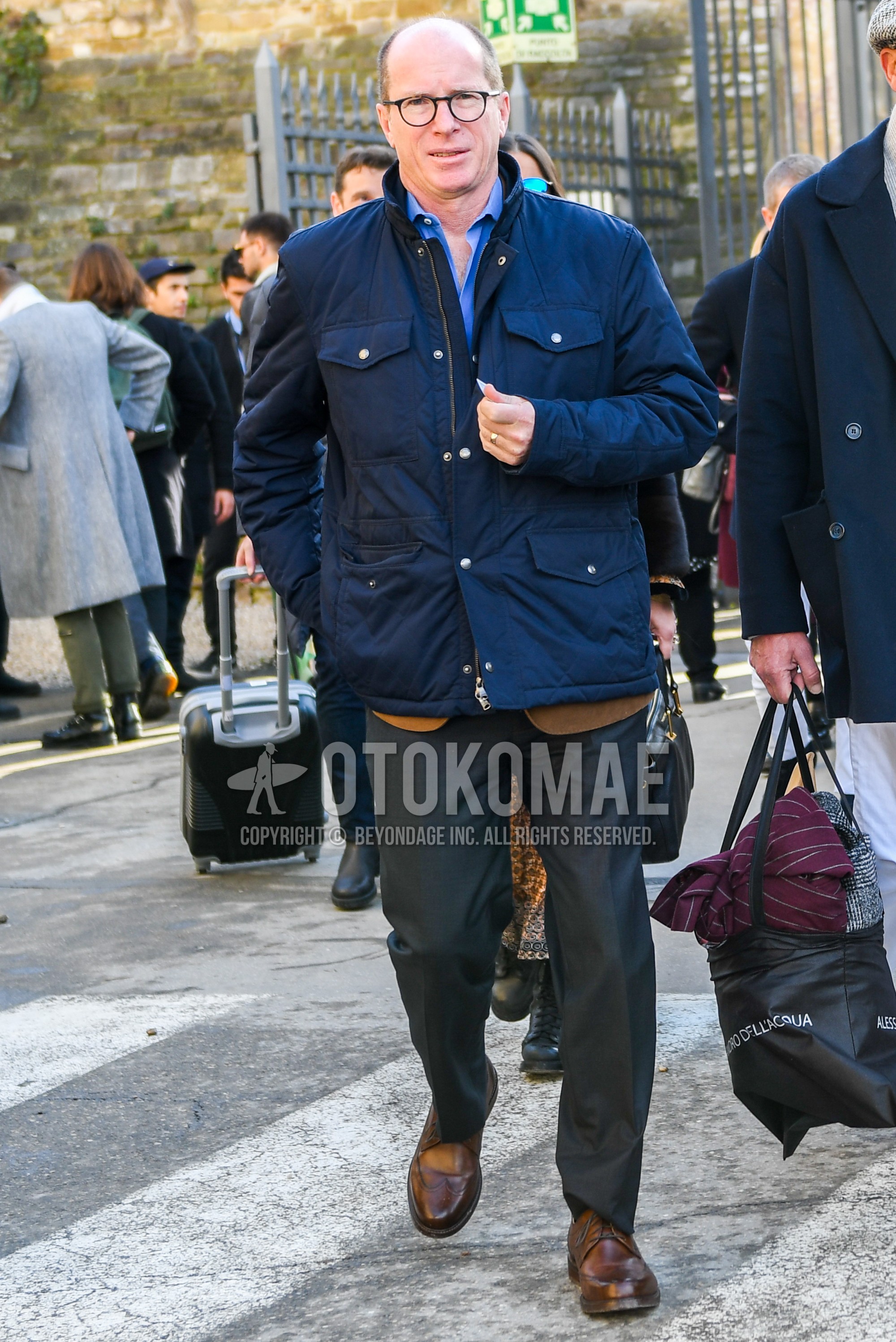 Men's winter outfit with plain glasses, navy plain M-65, blue plain shirt, dark gray plain slacks, brown suede shoes leather shoes.