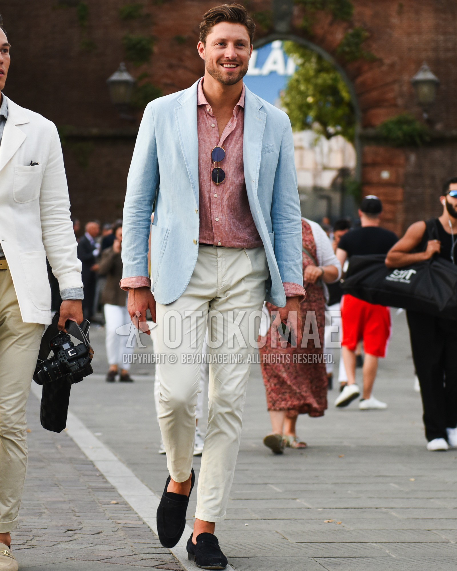 Men's spring summer outfit with gold plain sunglasses, light blue plain tailored jacket, red plain shirt, black plain leather belt, white plain cotton pants, navy coin loafers leather shoes, navy suede shoes leather shoes.
