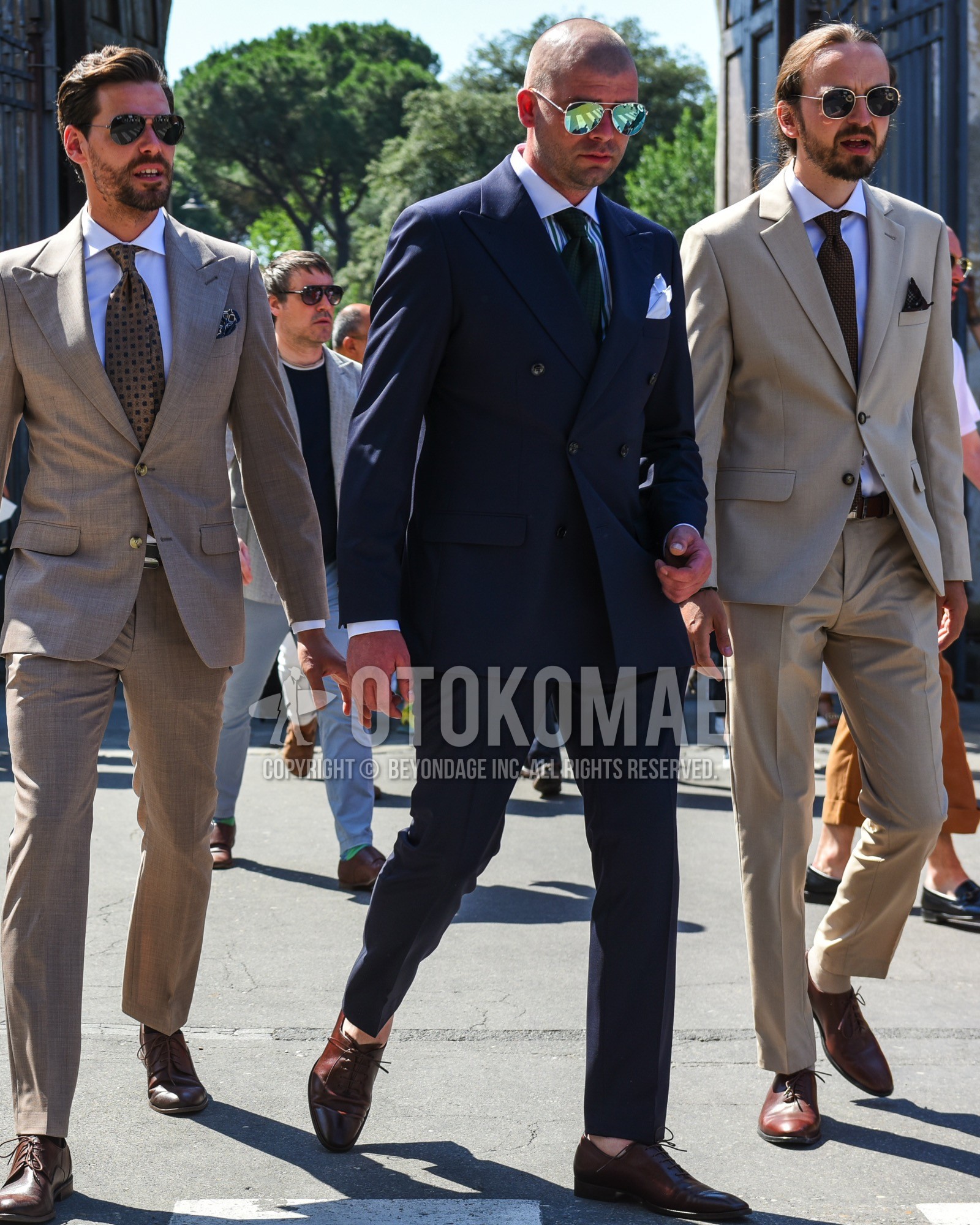 Men's spring summer outfit with silver plain sunglasses, white green stripes shirt, brown straight-tip shoes leather shoes, navy plain suit, green plain necktie.