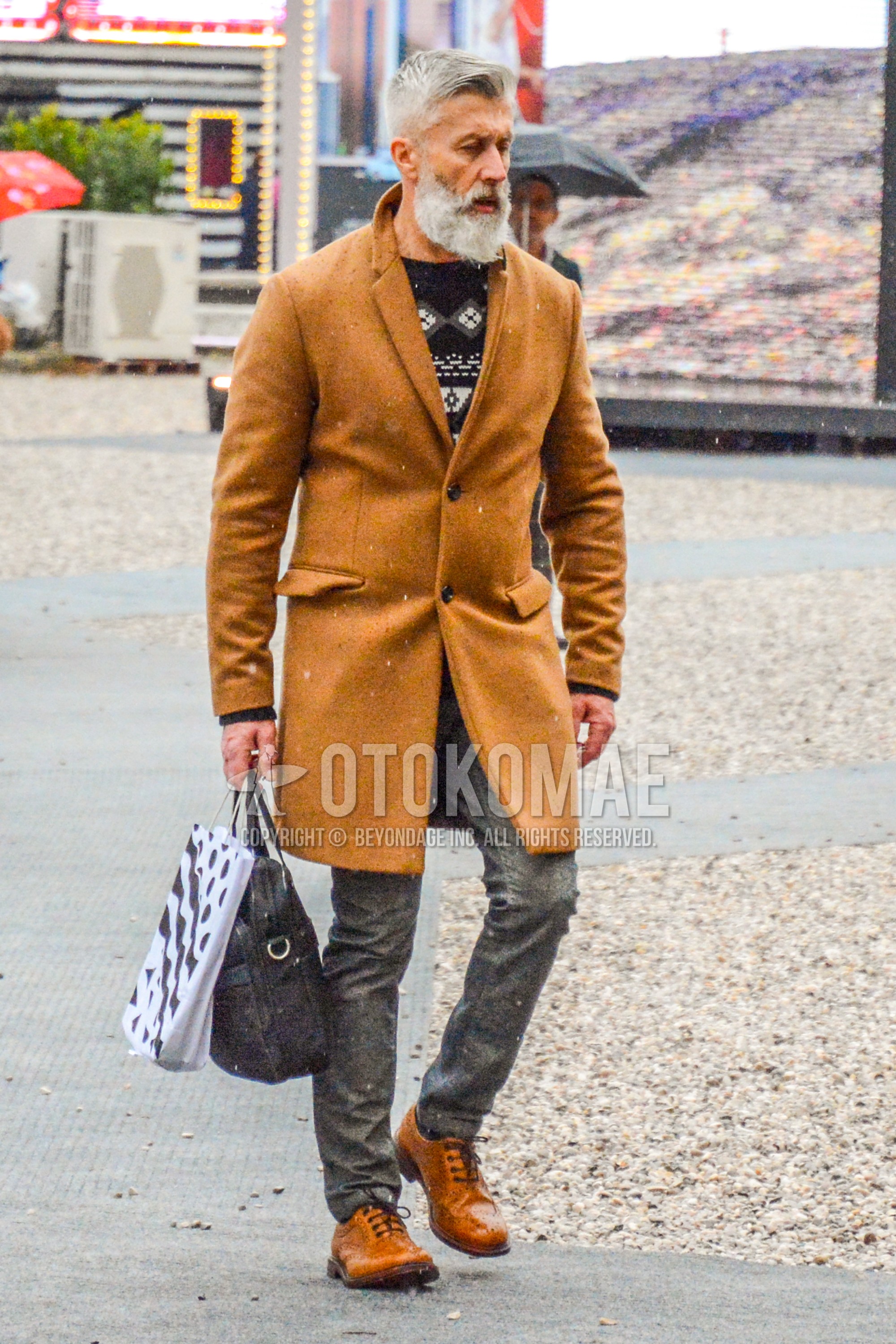 Men's autumn winter outfit with beige plain chester coat, black tops/innerwear sweater, gray plain cotton pants, brown wing-tip shoes leather shoes, black plain briefcase/handbag.