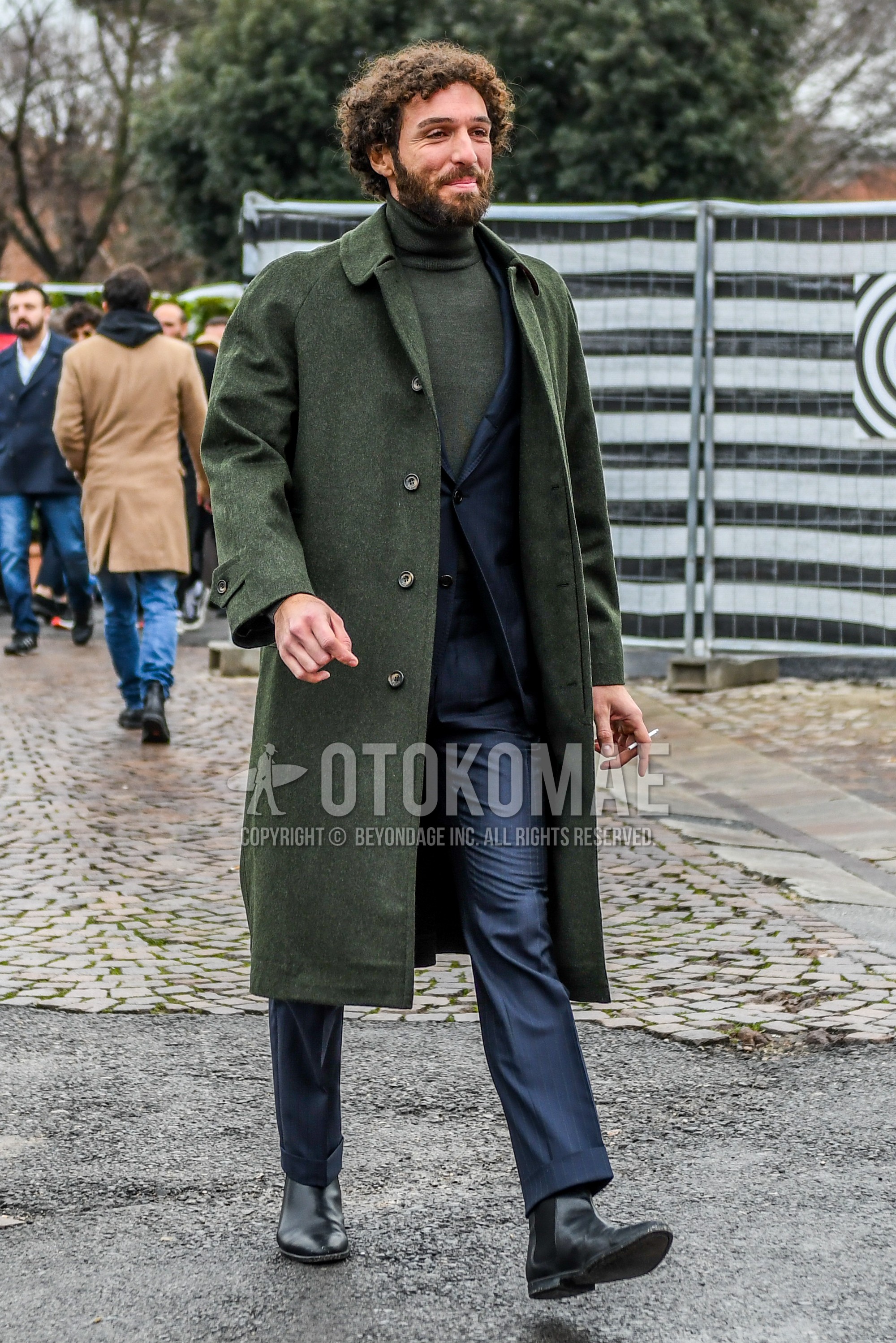 Men's winter outfit with olive green plain stenkarrer coat, olive green plain turtleneck knit, black side-gore boots, gray plain suit.