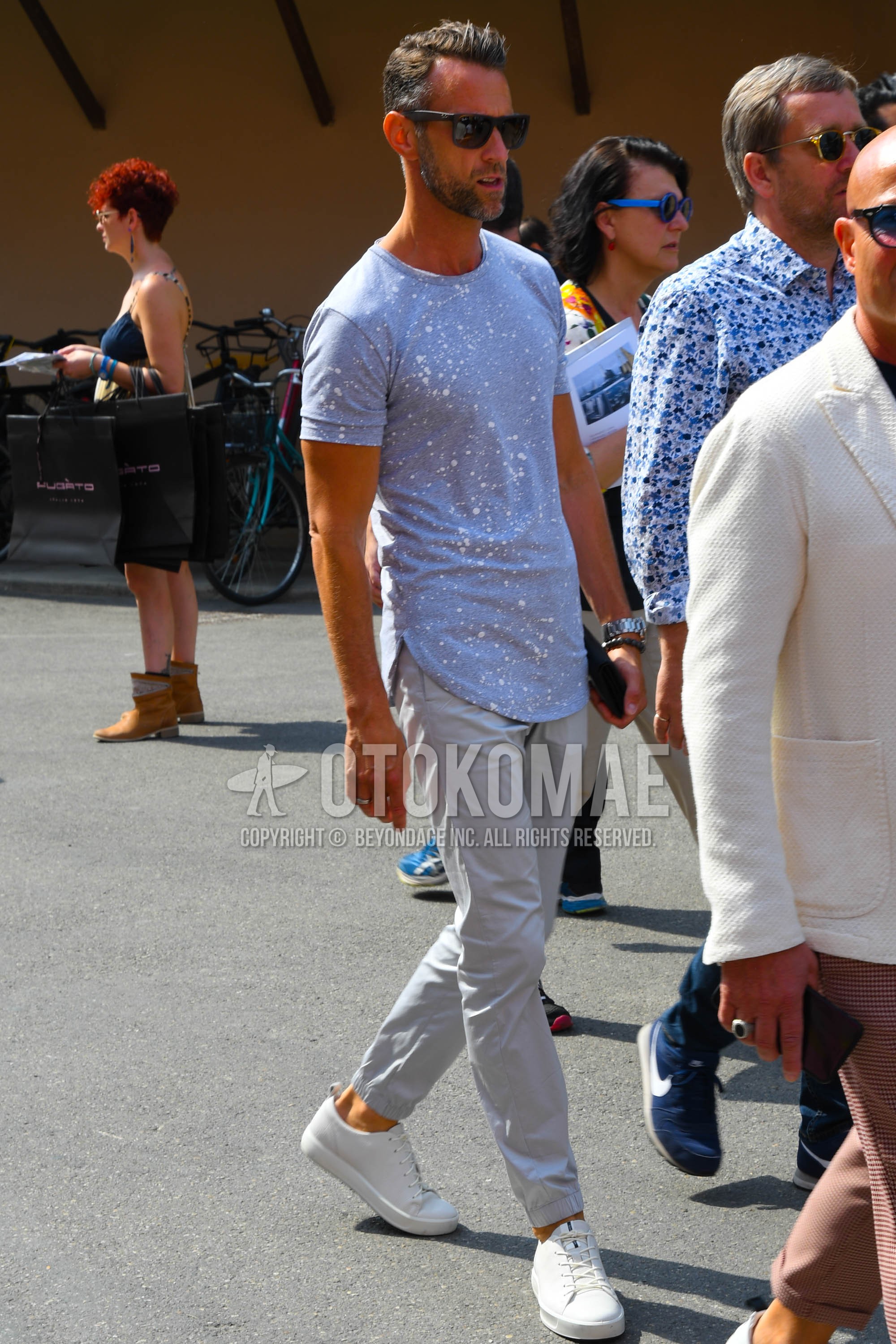 Men's spring summer outfit with plain sunglasses, gray plain t-shirt, gray plain chinos, white low-cut sneakers.