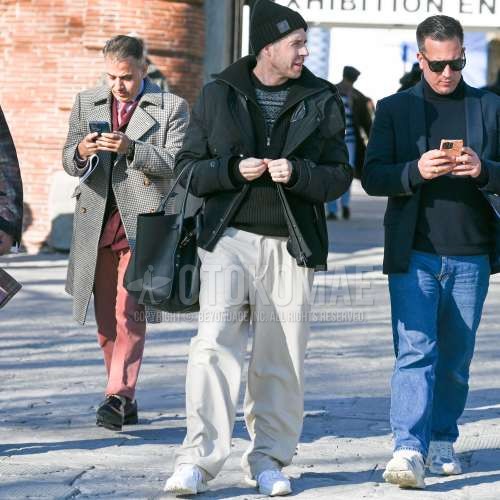 黒無地のニットキャップ、ダークグレー無地のアウター、ダークグレートップス/インナーのセーター、白無地のワイドパンツ、ニューバランスの白ローカットのスニーカーを合わせた冬のメンズコーデ・着こなし。