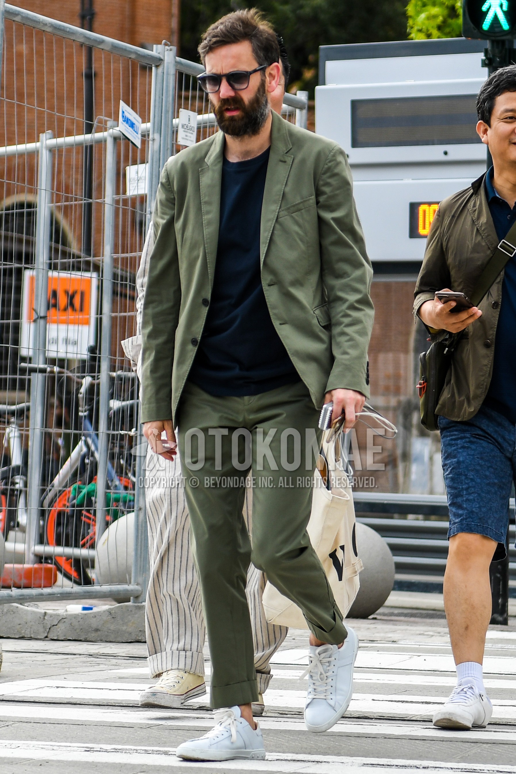 Men's spring summer autumn outfit with navy plain t-shirt, white low-cut sneakers, olive green plain suit.