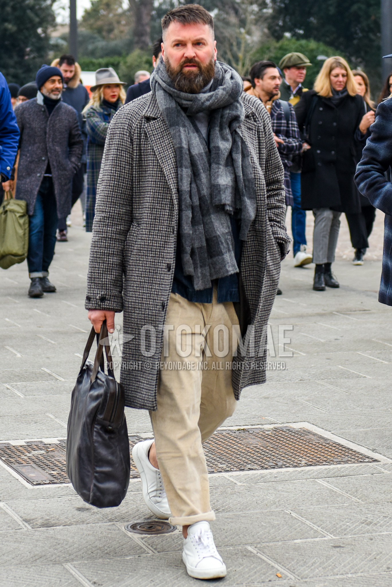 Men's winter outfit with gray check scarf, gray check chester coat, beige plain wide pants, beige plain cotton pants, white low-cut sneakers, brown plain tote bag.