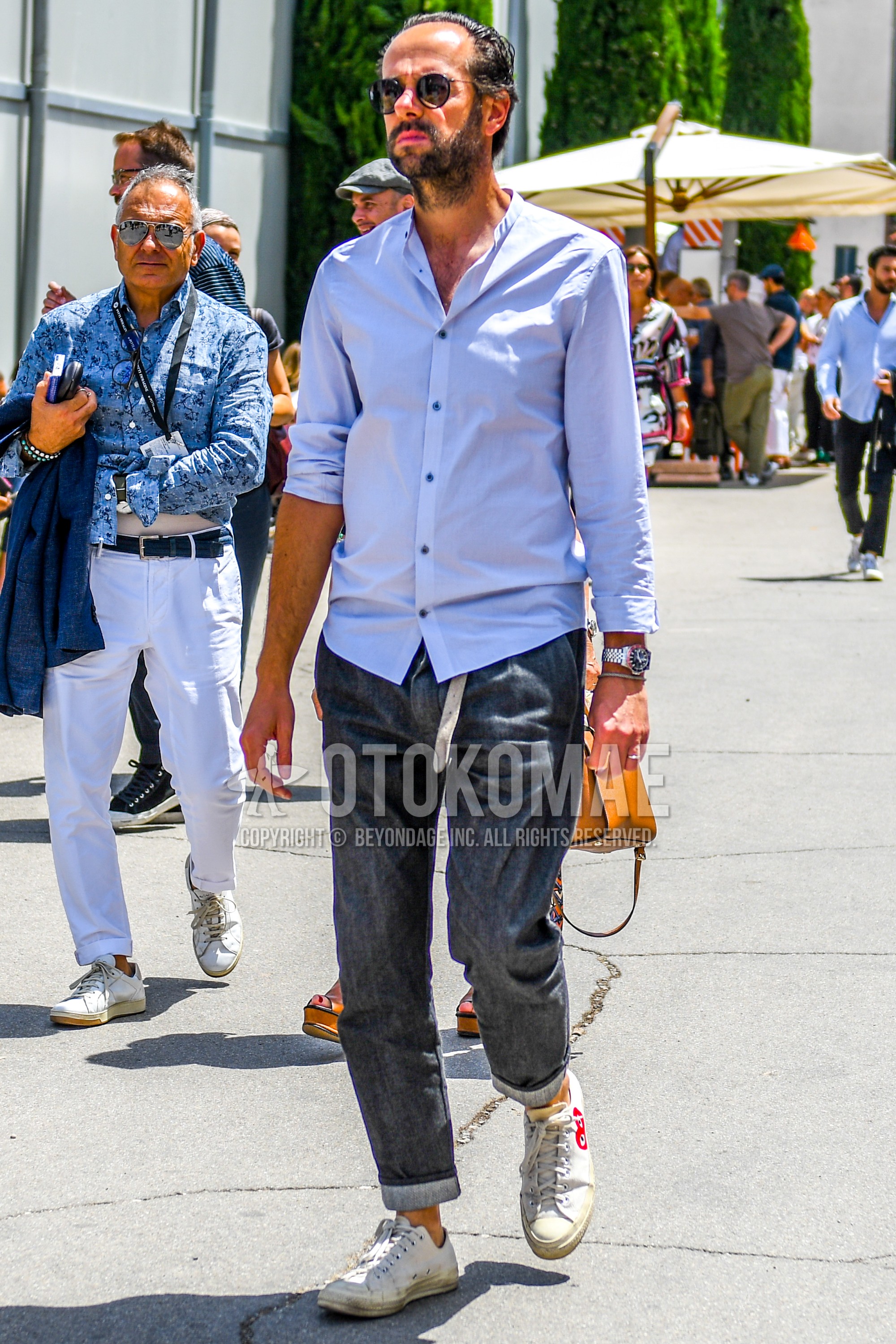 Men's spring summer outfit with plain sunglasses, blue plain shirt, gray plain denim/jeans, white low-cut sneakers.