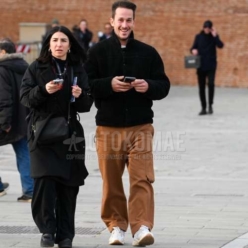 黒無地のフリースジャケット、白無地のロンT、ブラウン無地のワイドパンツ、白ローカットのスニーカーを合わせた秋冬のメンズコーデ・着こなし。