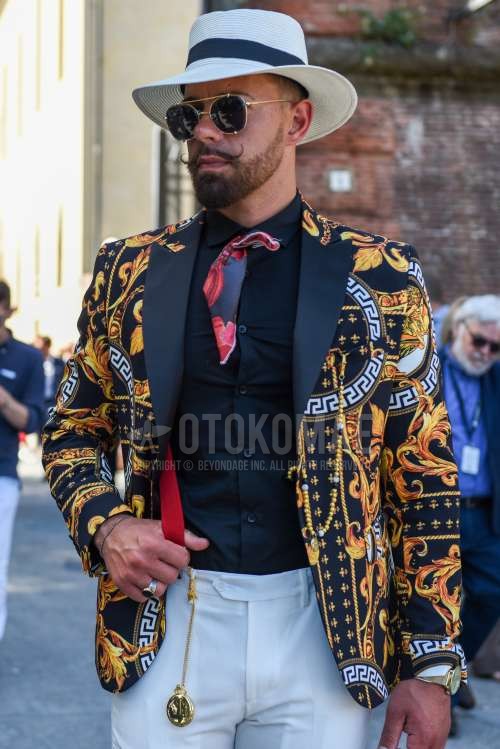 白無地のハット、ゴールド・黒無地のサングラス、オレンジ・黒アウターのテーラードジャケット、黒無地のシャツ、白無地のベルトレスパンツ、黒・レッドネクタイのネクタイを合わせた春夏秋のメンズコーデ・着こなし。