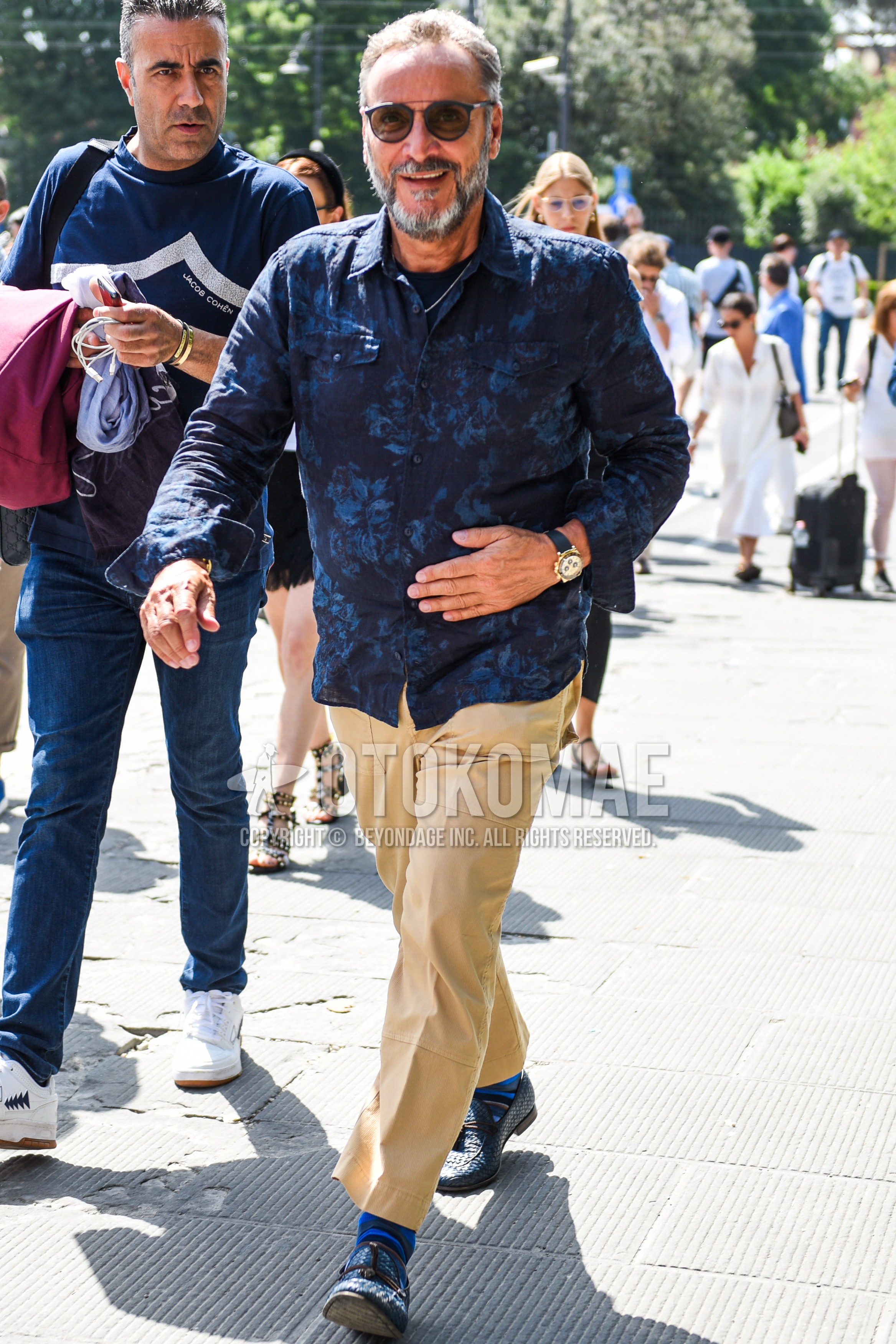 Men's spring summer autumn outfit with black plain sunglasses, navy tops/innerwear shirt, beige plain cotton pants, blue plain socks, blue tassel loafers leather shoes.