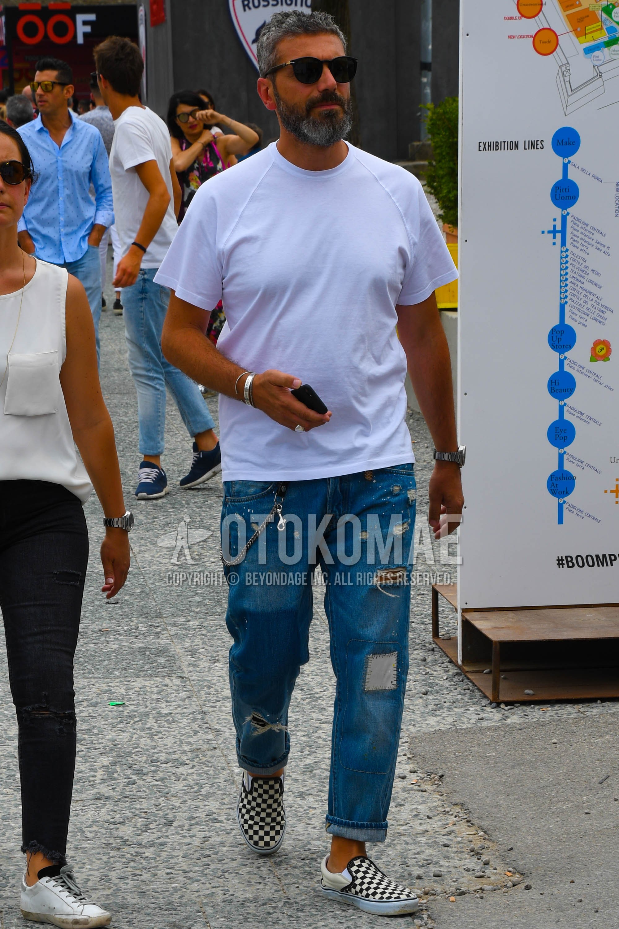 Men's summer outfit with plain sunglasses, white plain t-shirt, blue plain damaged jeans, white black slip-on sneakers.