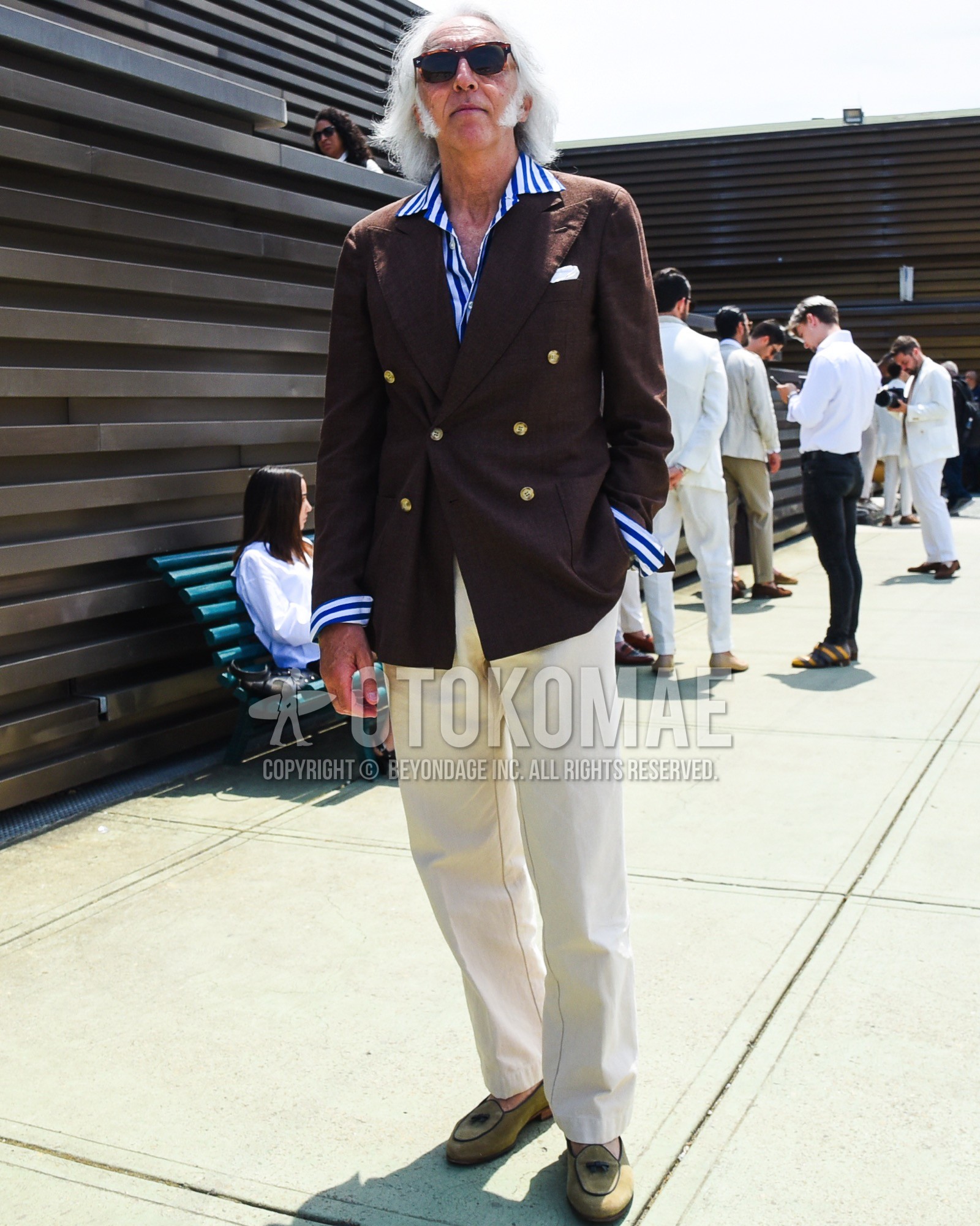 Men's spring summer outfit with brown tortoiseshell sunglasses, brown plain tailored jacket, navy white stripes shirt, beige plain slacks, green  loafers leather shoes.
