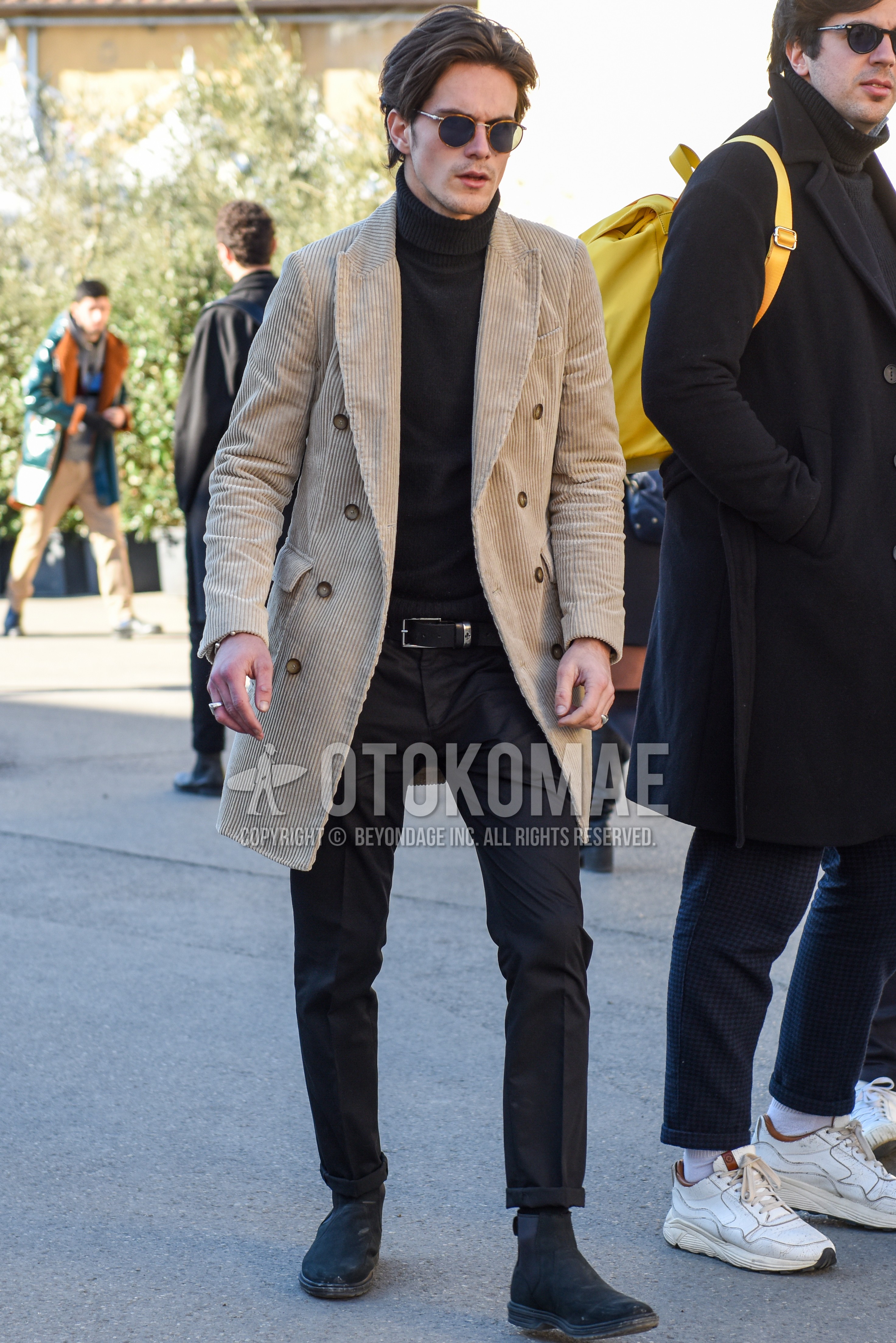 Men's autumn winter outfit with brown tortoiseshell sunglasses, beige plain chester coat, black plain turtleneck knit, black plain leather belt, gray plain slacks, black plain socks, gray  boots.