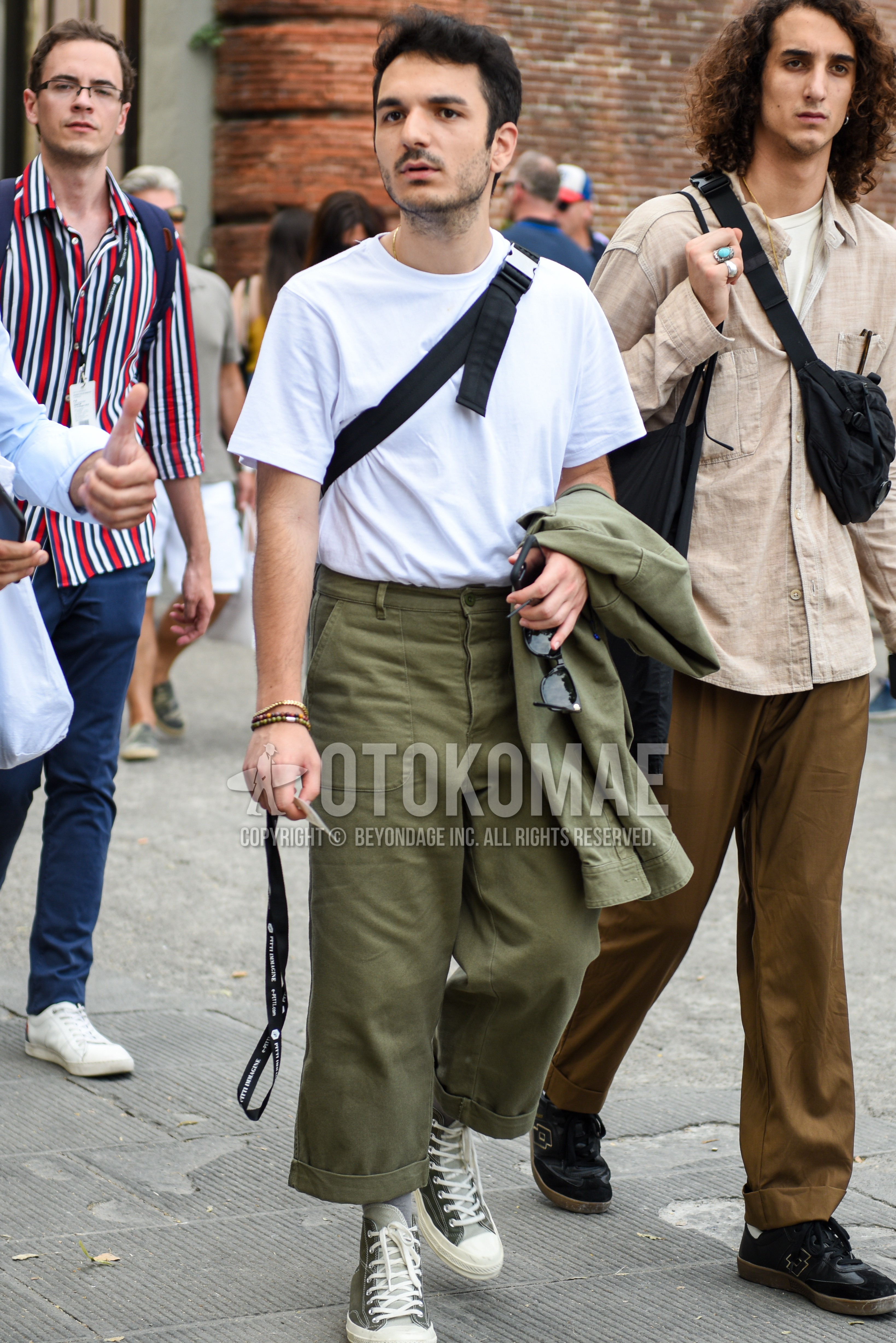 Men's summer outfit with white plain t-shirt, olive green plain wide pants, green high-cut sneakers.