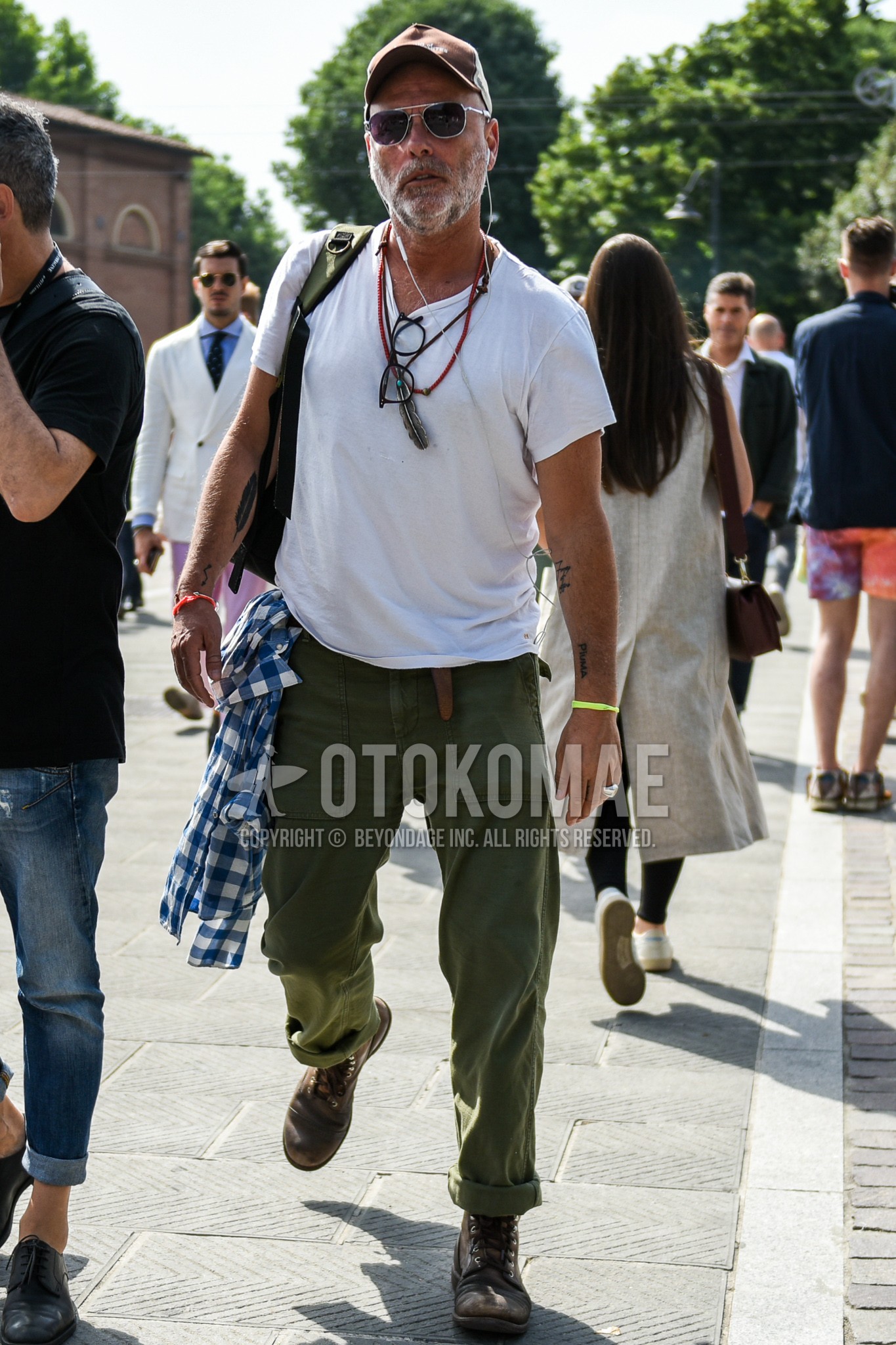 Men's summer outfit with brown plain baseball cap, plain sunglasses, white plain t-shirt, olive green plain chinos, brown work boots.