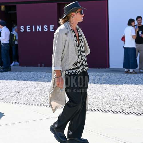 黒無地のハット、黒無地のサングラス、グレー無地のアウター、白トップス/インナーのシャツ、ダークグレー無地のスラックス、ダークグレー無地のプリーツパンツ、黒コインローファーの革靴を合わせた春夏秋のメンズコーデ・着こなし。