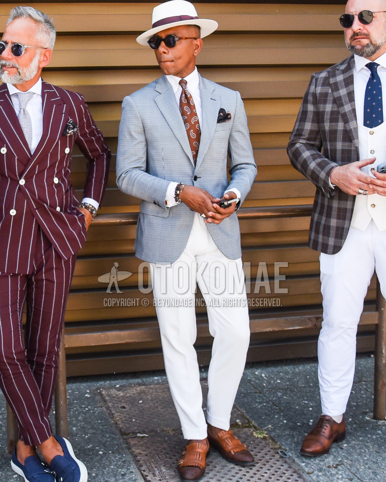 Men's spring summer outfit with white plain hat, black plain sunglasses, gray check tailored jacket, white plain shirt, white plain slacks, brown monk shoes leather shoes, brown paisley necktie.