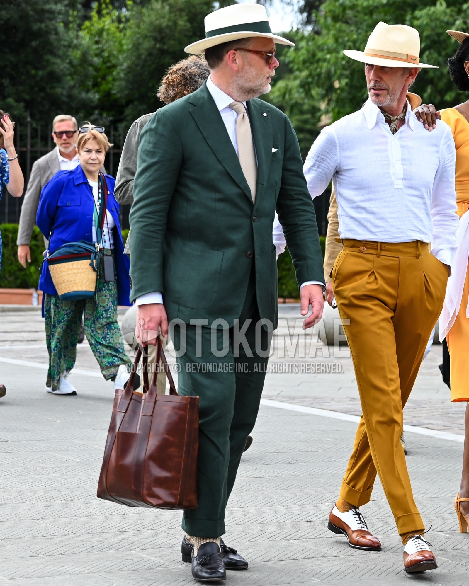 Men's spring summer autumn outfit with white plain hat, white plain shirt, black tassel loafers leather shoes, brown plain briefcase/handbag, green plain suit, beige plain necktie.