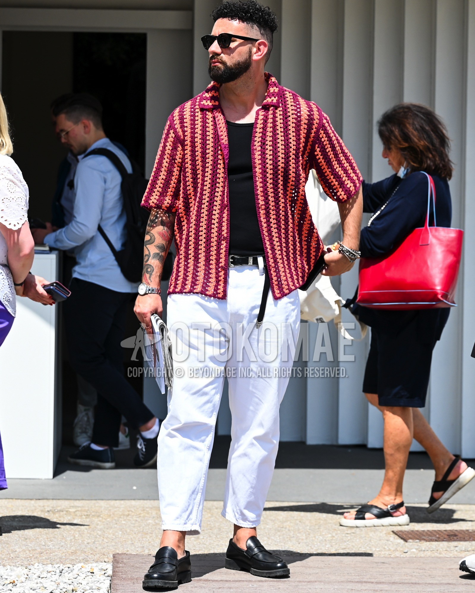 Men's spring summer outfit with black plain sunglasses, red stripes shirt, black plain t-shirt, black plain leather belt, white plain chinos, black coin loafers leather shoes.