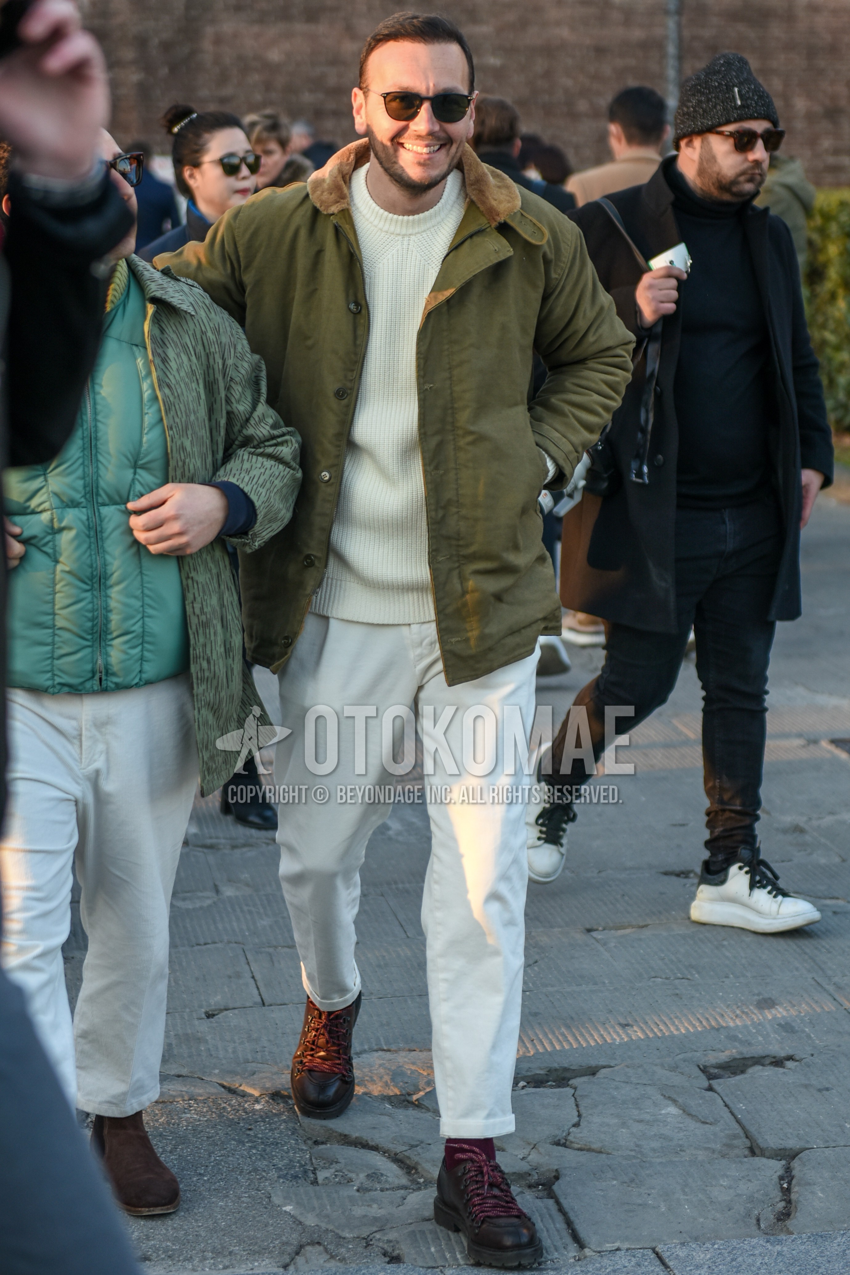 Men's autumn winter outfit with black plain sunglasses, olive green plain field jacket/hunting jacket, white plain sweater, white plain cotton pants, brown  boots.