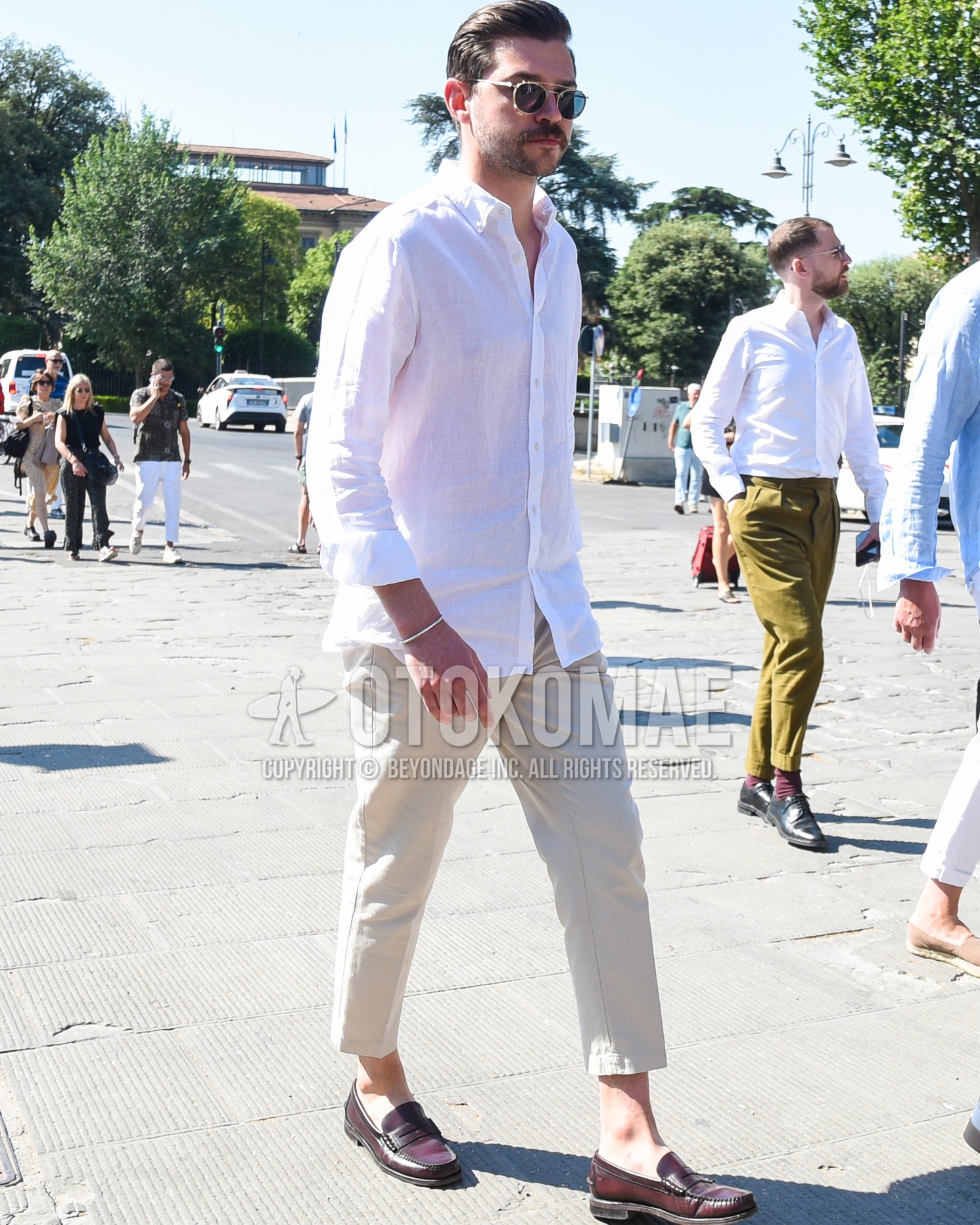 Men's spring summer outfit with gold plain sunglasses, white plain shirt, white plain slacks, white plain cropped pants, brown coin loafers leather shoes.