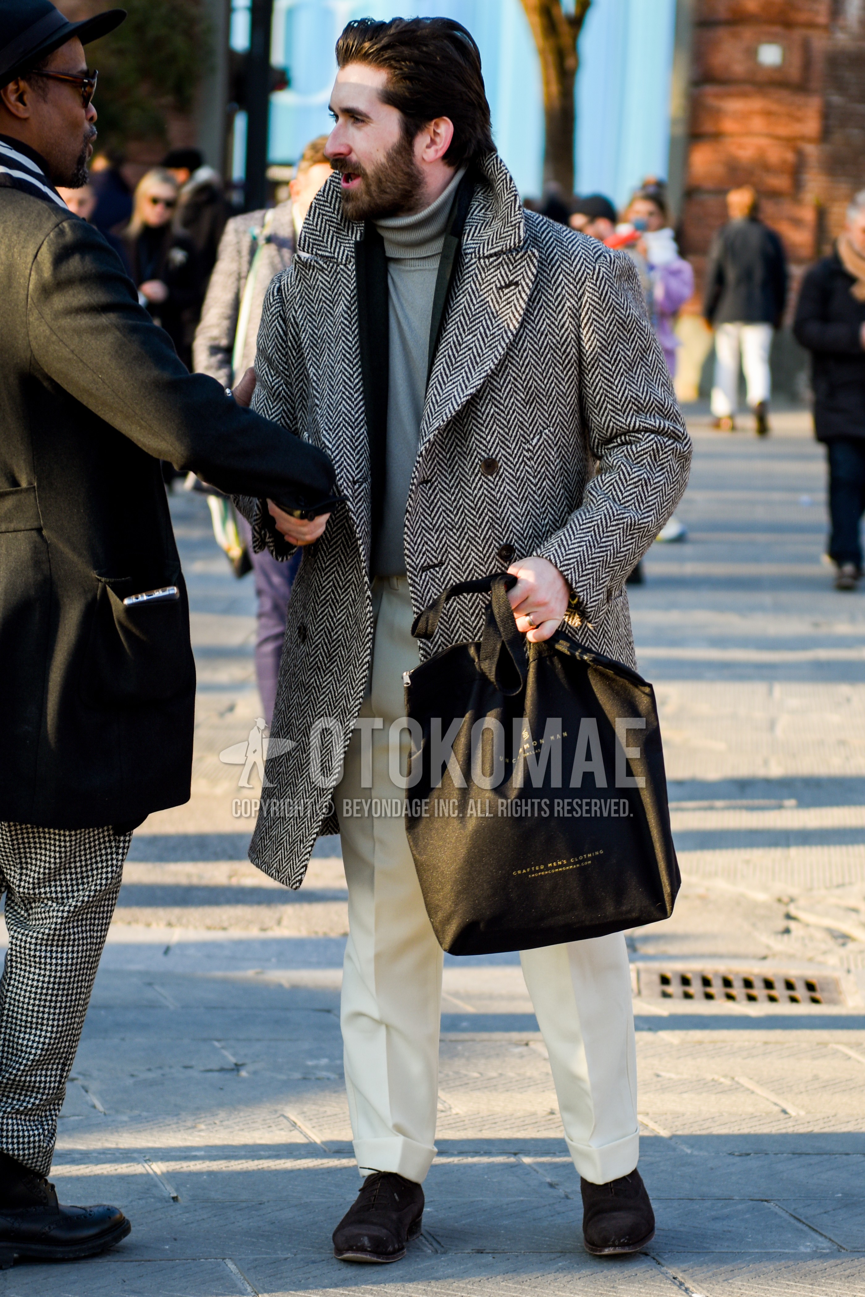 Men's autumn winter outfit with gray herringbone chester coat, black plain tailored jacket, gray plain turtleneck knit, white plain slacks, brown plain toe leather shoes.
