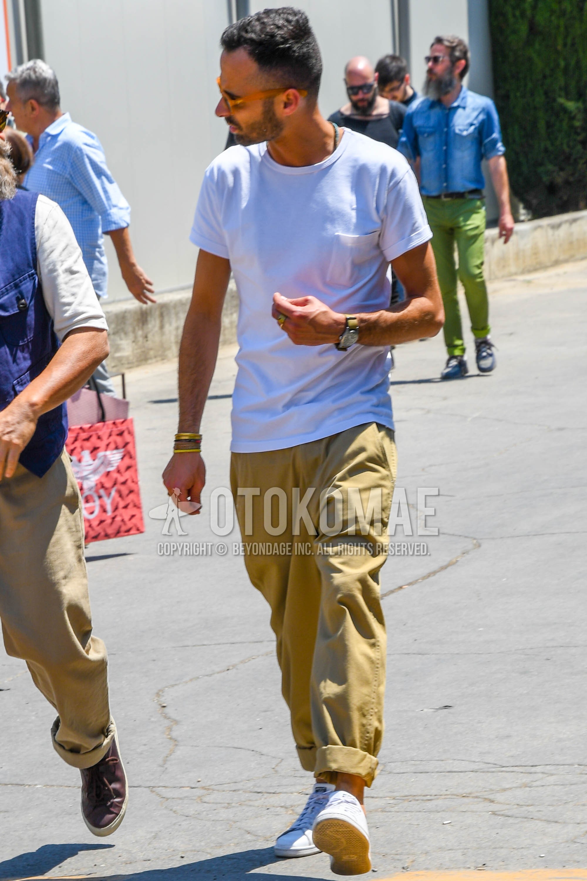 Men's summer outfit with white plain t-shirt, beige plain wide pants, white low-cut sneakers.
