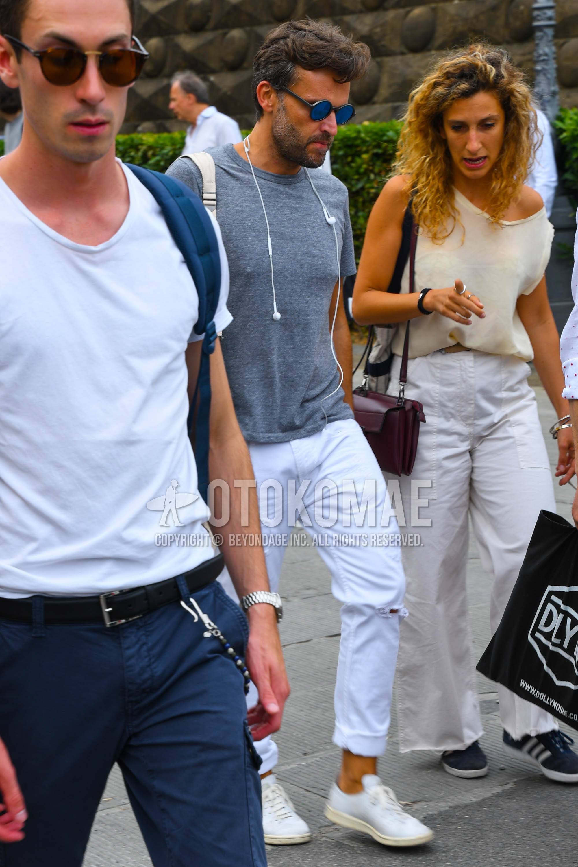 Men's summer outfit with plain sunglasses, gray plain t-shirt, white plain damaged jeans, white low-cut sneakers.