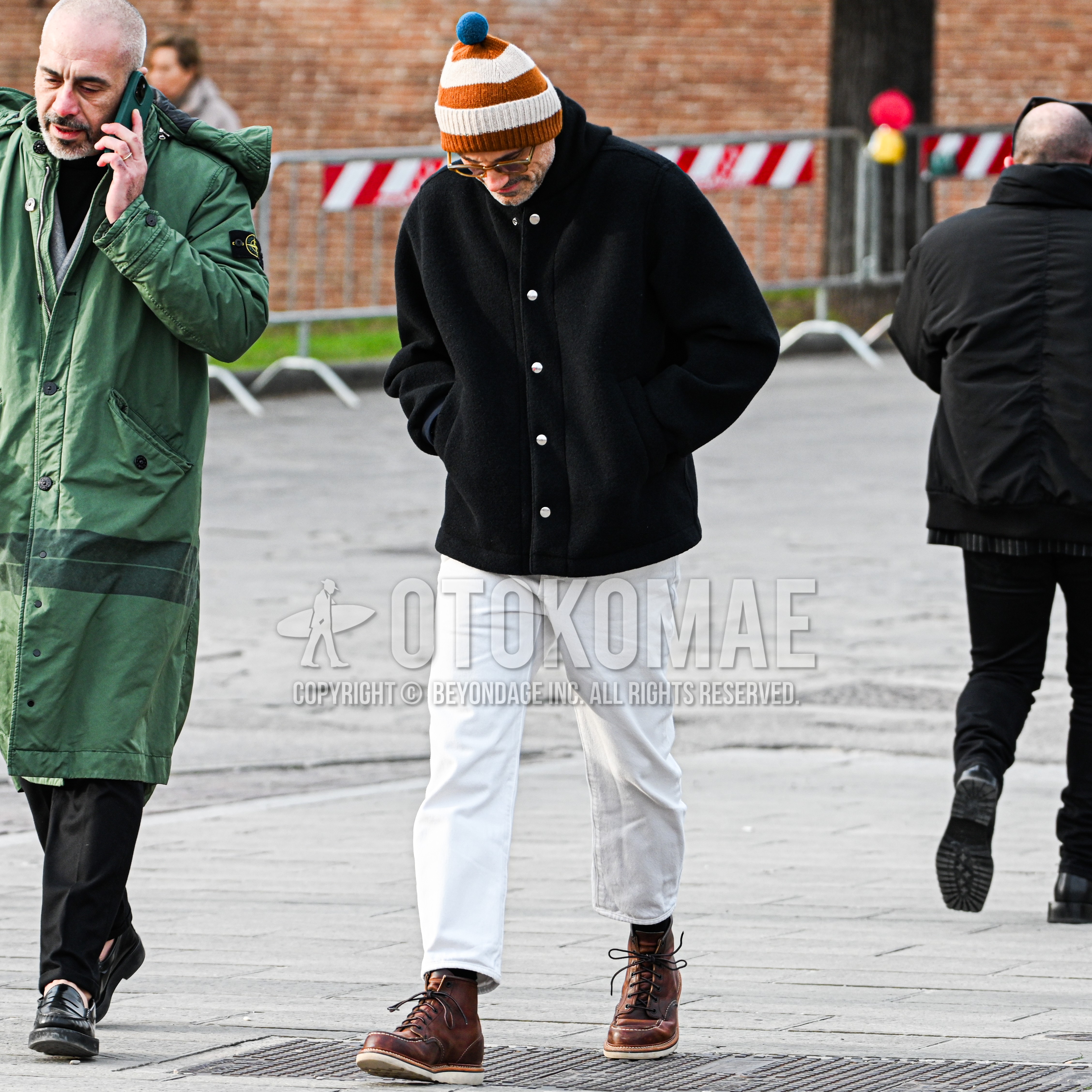 Men's autumn winter outfit with white orange horizontal stripes knit cap, yellow plain glasses, black plain hooded coat, white plain cotton pants, brown work boots.