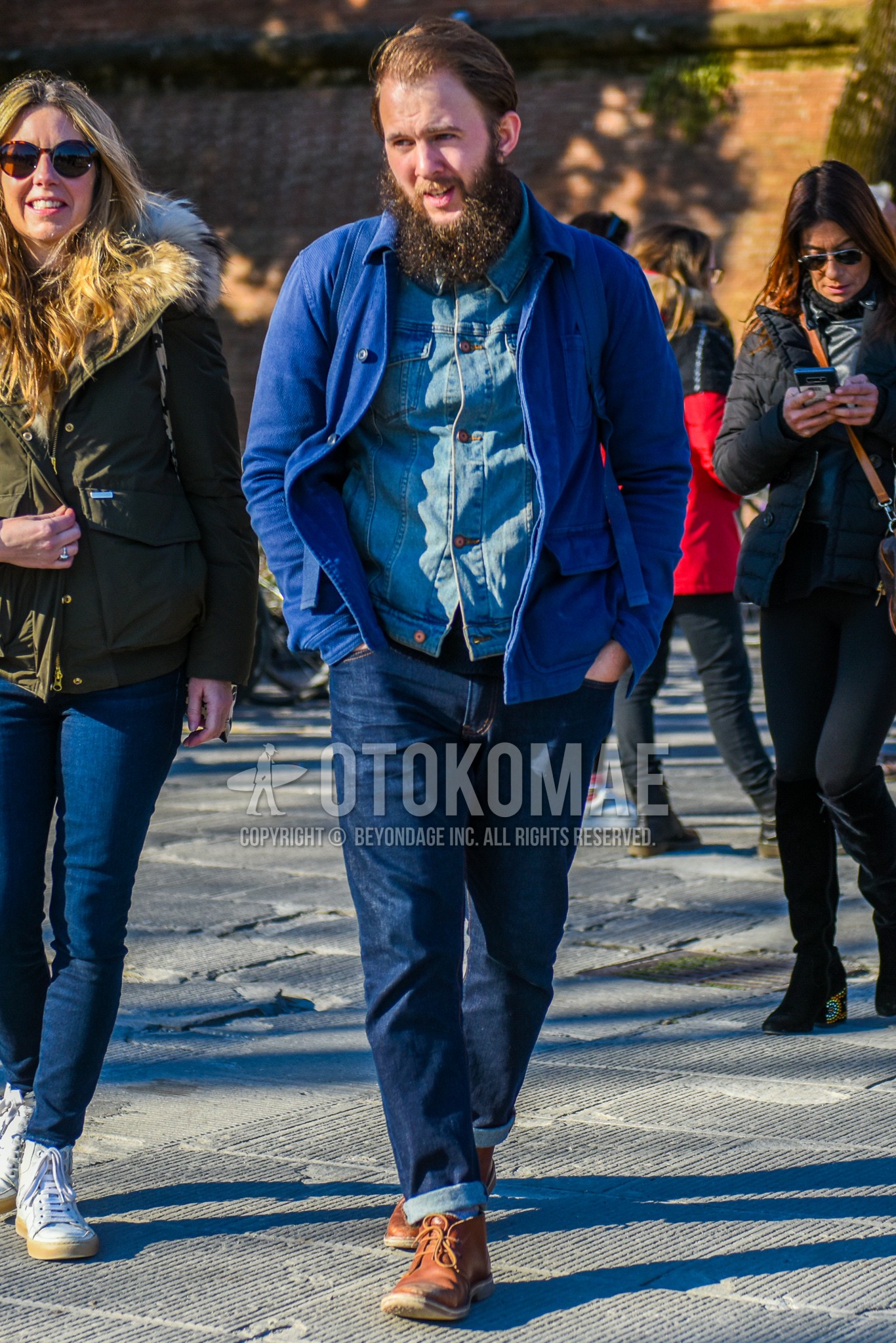 Men's autumn winter outfit with blue plain outerwear, blue plain denim jacket, blue plain denim/jeans, brown chukka boots.