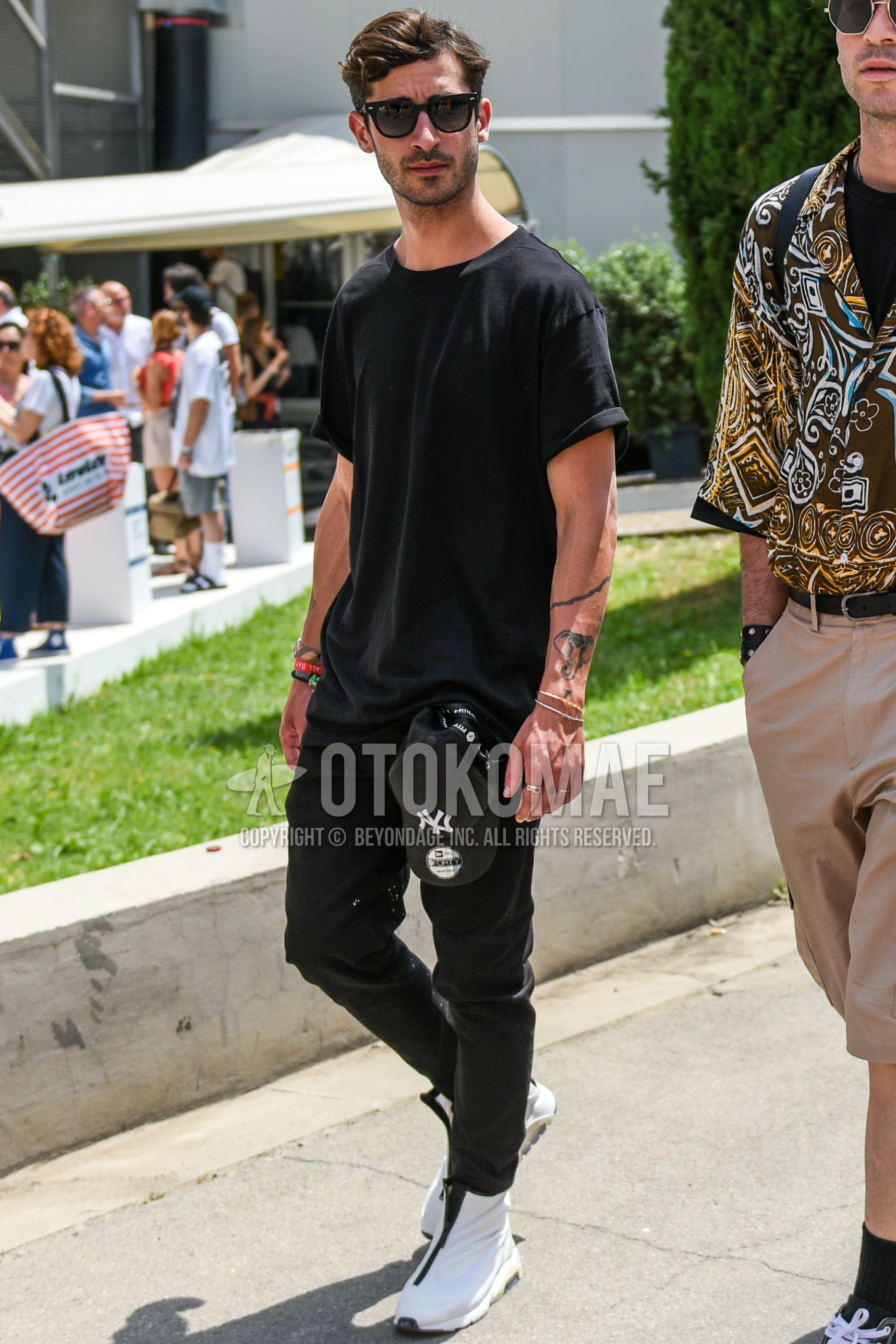 Men's summer outfit with black plain sunglasses, black plain t-shirt, black plain denim/jeans, white high-cut sneakers.