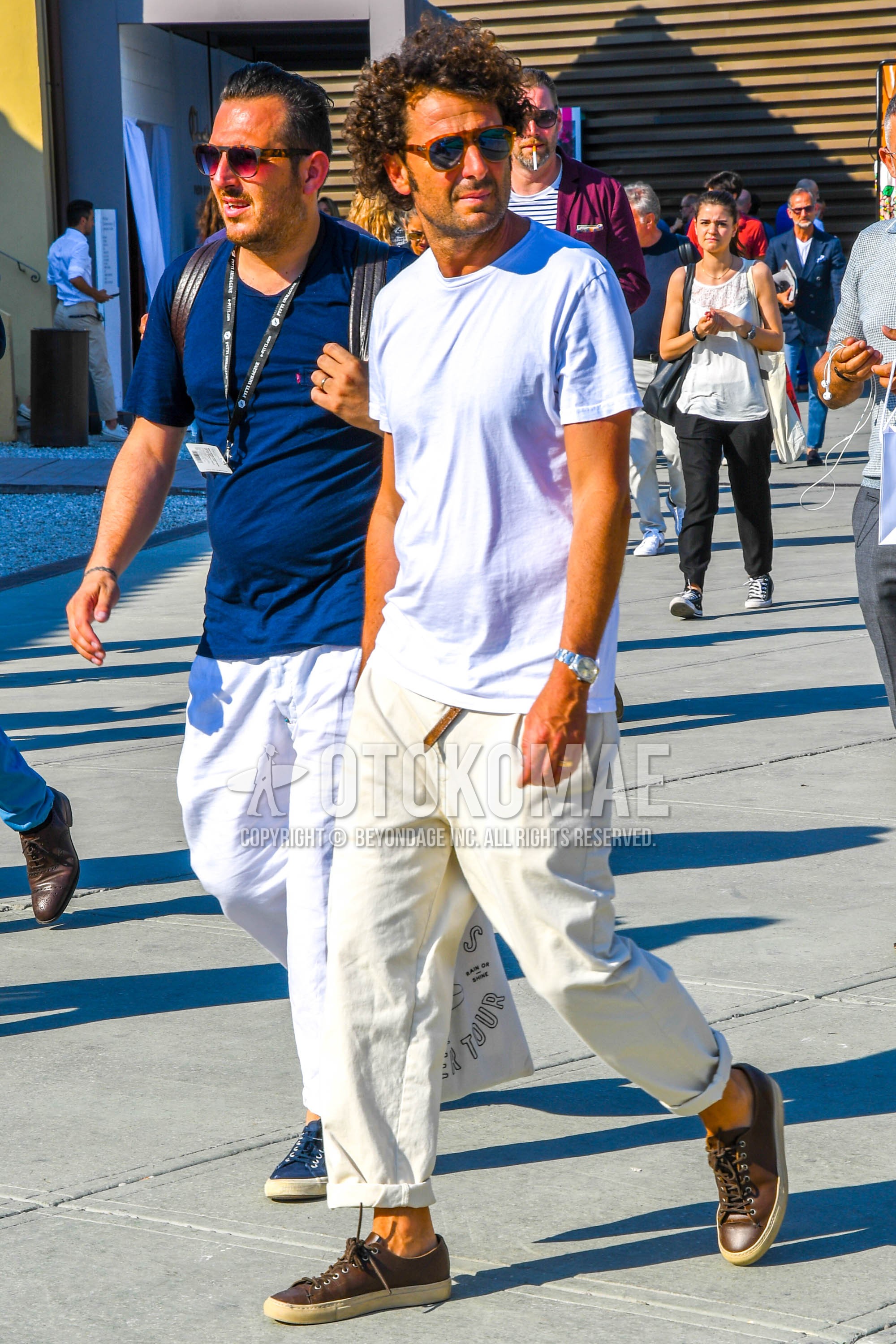 Men's summer outfit with plain sunglasses, white plain t-shirt, white plain wide pants, brown low-cut sneakers.