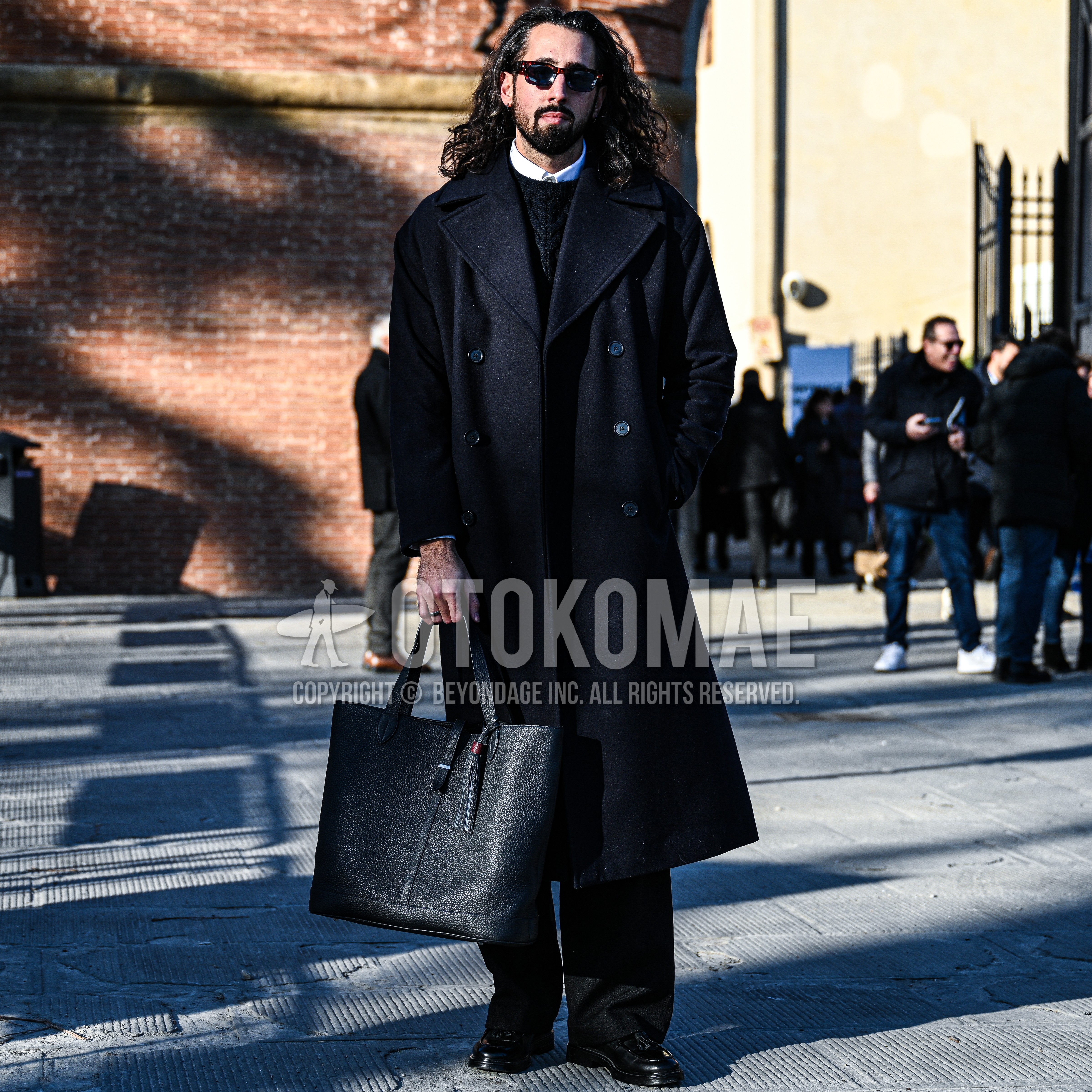 Men's autumn winter outfit with tortoiseshell sunglasses, navy plain ulster coat, white plain shirt, black plain sweater, black plain slacks, black tassel loafers leather shoes, black plain tote bag.