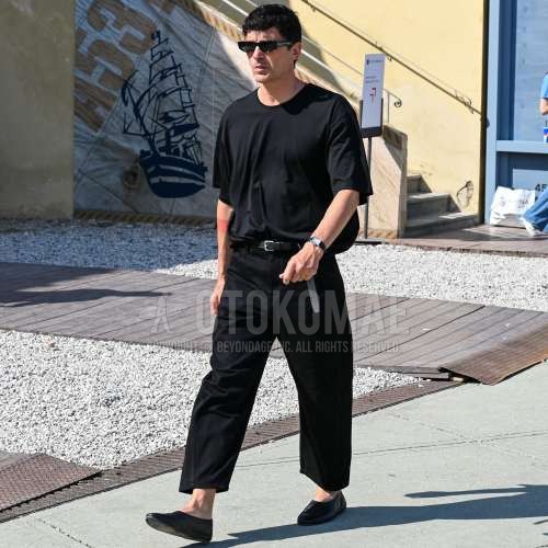 黒無地のサングラス、黒無地のTシャツ、黒無地のレザーベルト、黒無地のコットンパンツ、黒無地のアンクルパンツ、黒ローファーの革靴を合わせた春夏のメンズコーデ・着こなし。