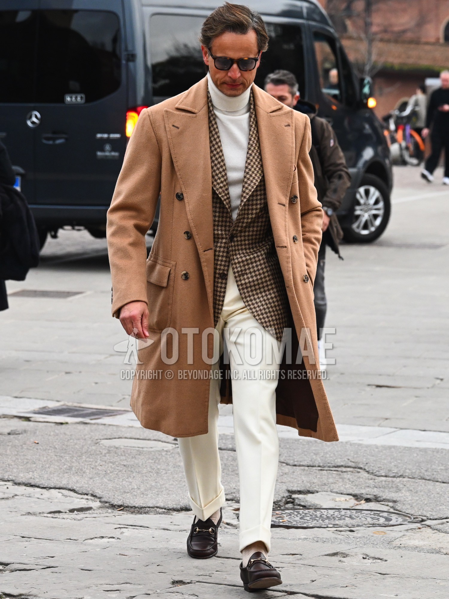 Men's autumn winter outfit with brown tortoiseshell sunglasses, blue plain chester coat, brown check tailored jacket, white plain turtleneck knit, white plain slacks, beige plain socks, bit loafers leather shoes.