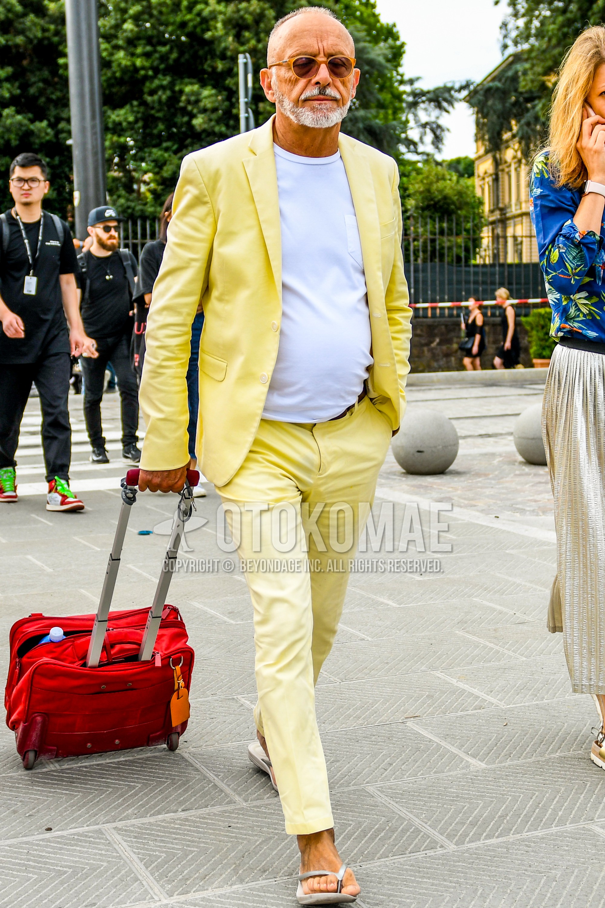 Men's spring summer autumn outfit with beige plain sunglasses, white plain t-shirt, gray flip flops sandals, red plain suitcase, yellow plain suit.