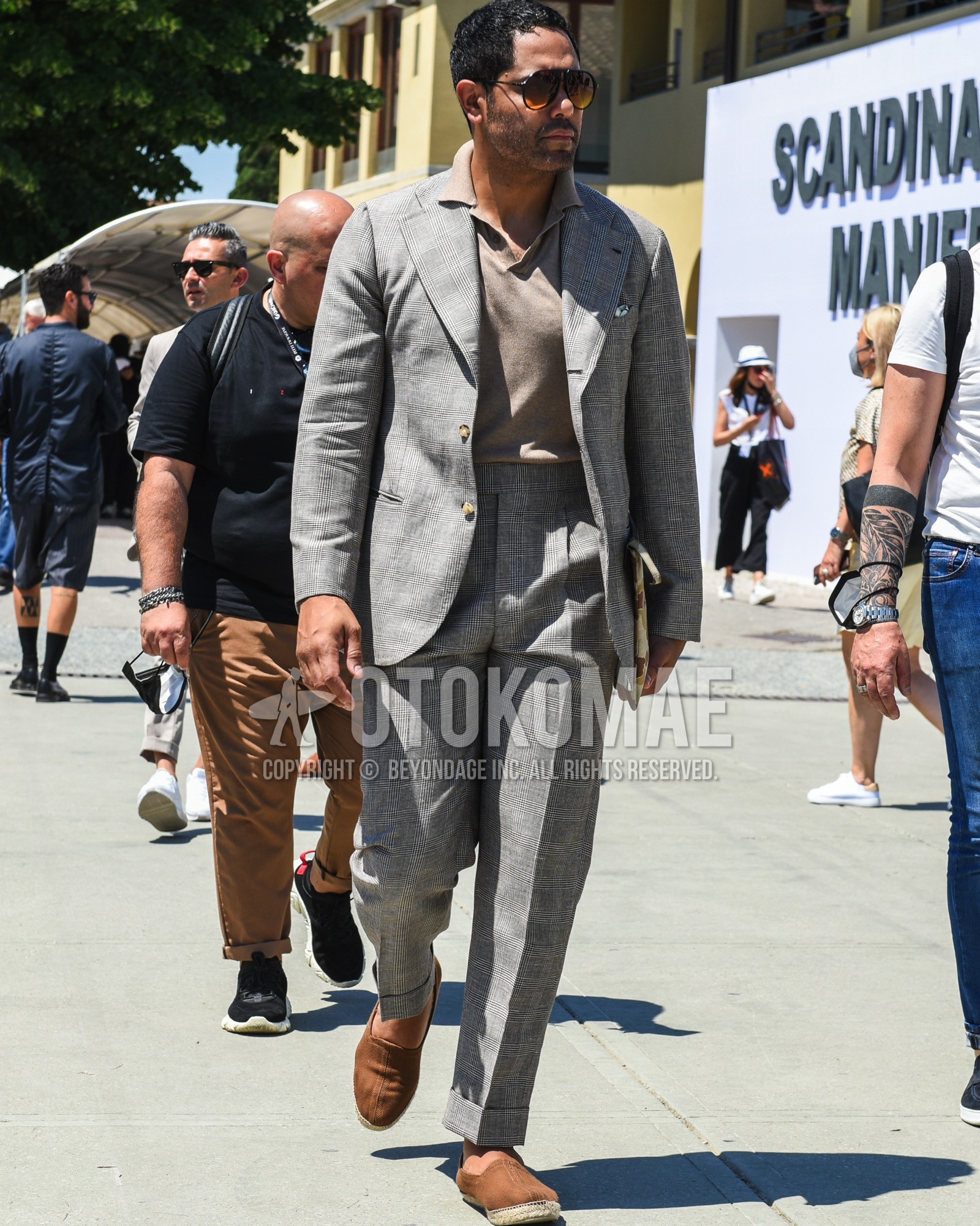 Men's spring summer outfit with black plain sunglasses, beige plain polo shirt, brown plain espadrille, gray plain suit.