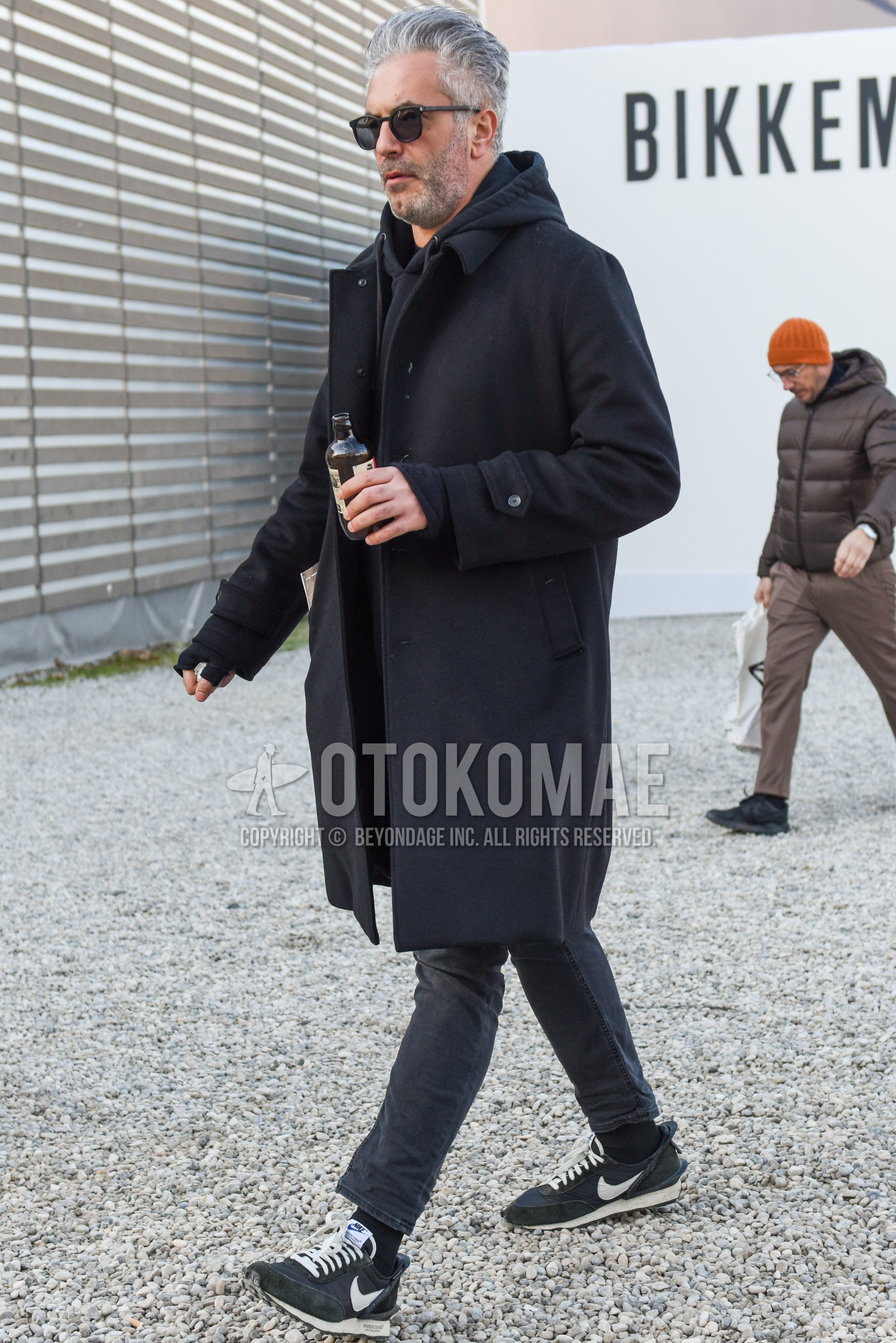 Men's autumn winter outfit with black plain sunglasses, black plain stenkarrer coat, black plain hoodie, plain denim/jeans, black plain socks, black low-cut sneakers.