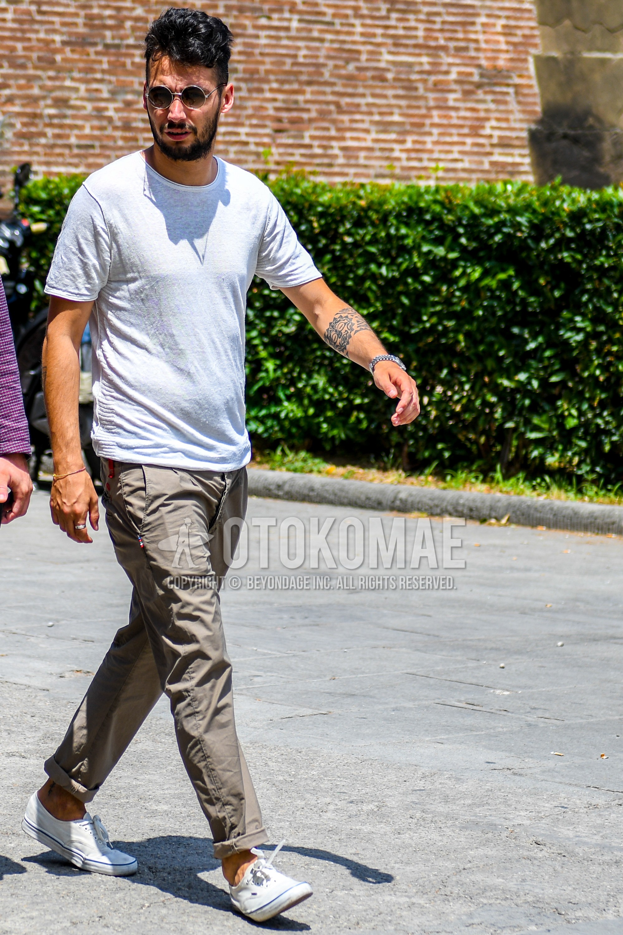 Men's summer outfit with plain sunglasses, gray plain t-shirt, olive green plain cotton pants, white low-cut sneakers.