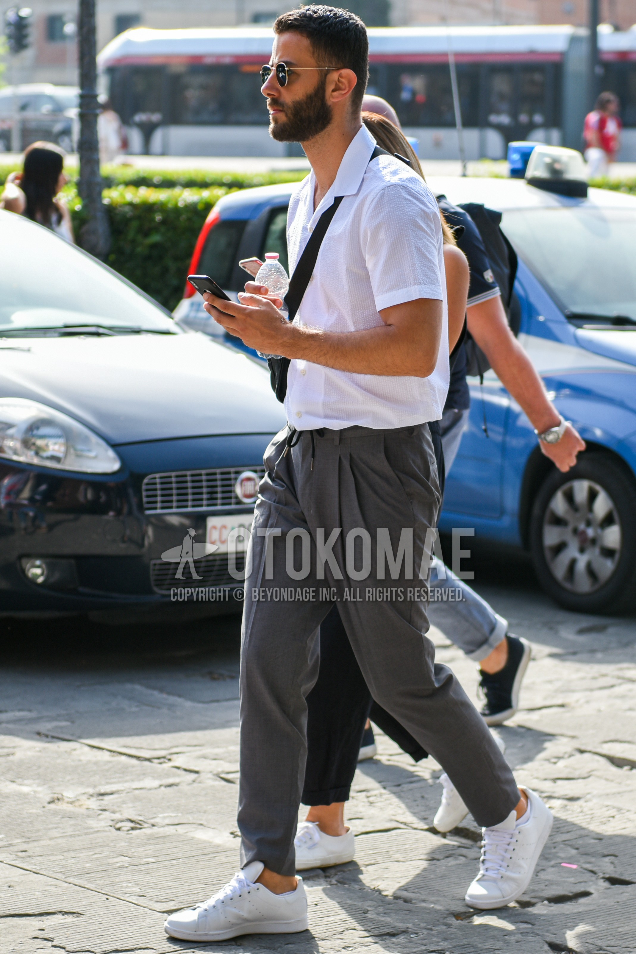 Men's summer outfit with gold plain sunglasses, white plain shirt, gray plain easy pants, white low-cut sneakers.