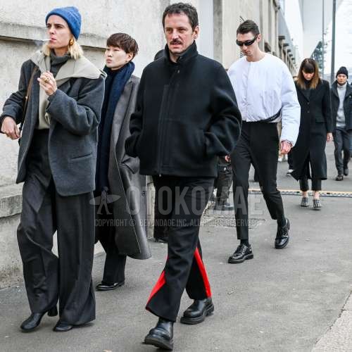 ダークグレー無地のアウター、黒・レッド無地のサイドラインパンツ、黒サイドゴアのブーツを合わせた冬のメンズコーデ・着こなし。