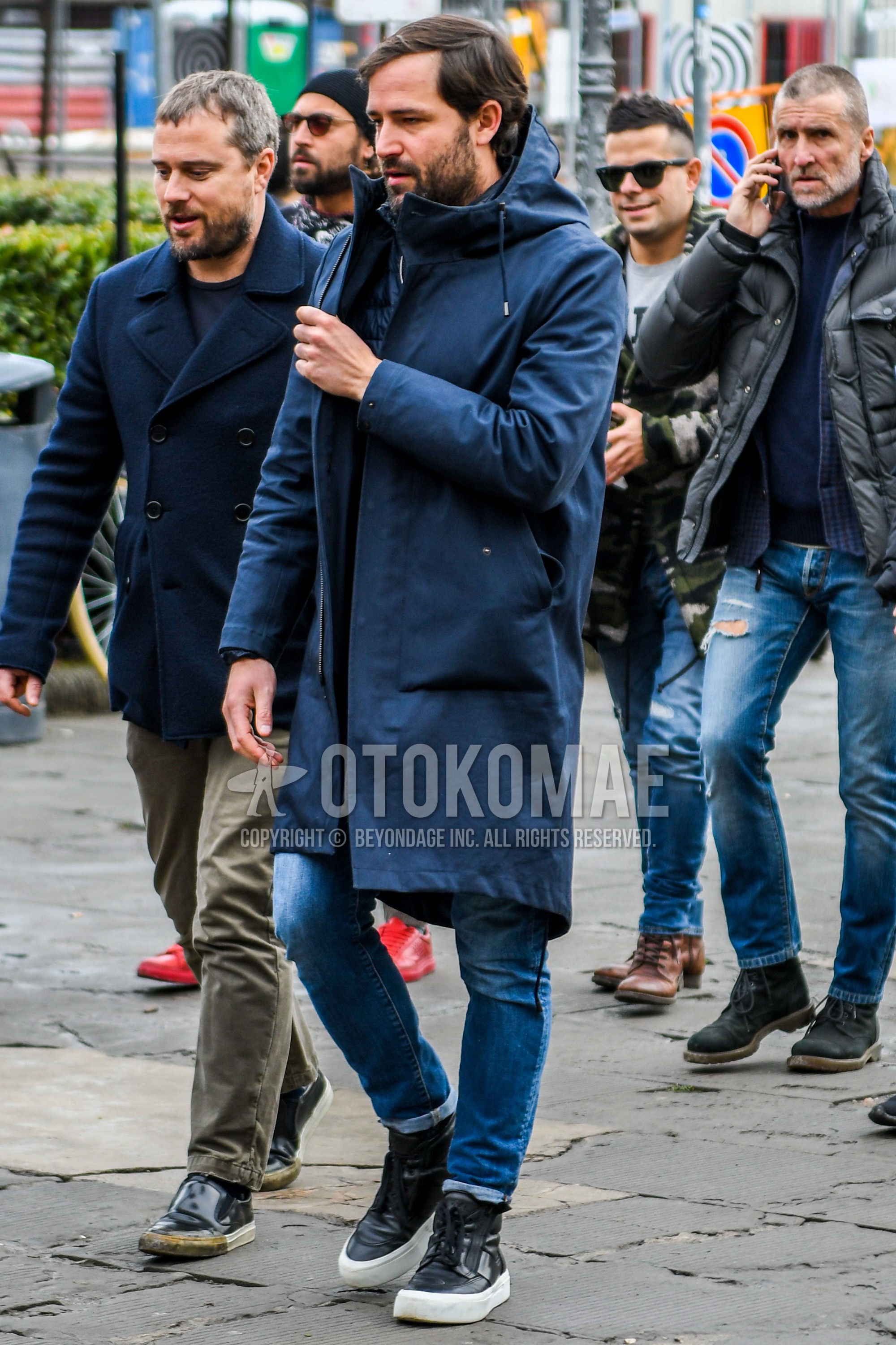 Men's winter outfit with navy plain hooded coat, blue plain denim/jeans, black high-cut sneakers.