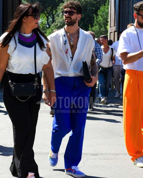 黒無地のサングラス、白無地のシャツ、ブルー無地のスラックス、ブルーローカットのスニーカー、黒無地のクラッチバッグ/セカンドバッグ/巾着を合わせた夏春のメンズコーデ・着こなし。