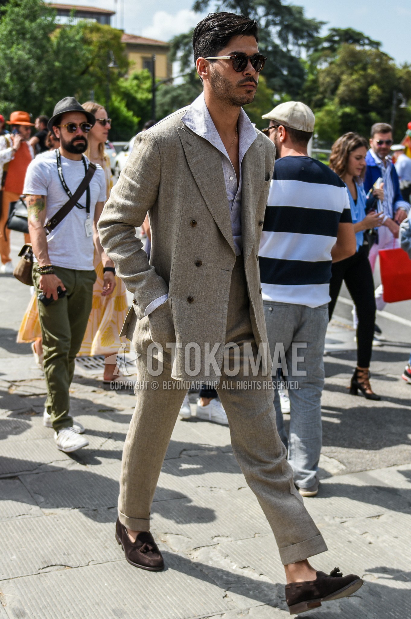 Men's spring summer outfit with brown white tortoiseshell sunglasses, gray plain shirt, brown tassel loafers leather shoes, beige plain suit.