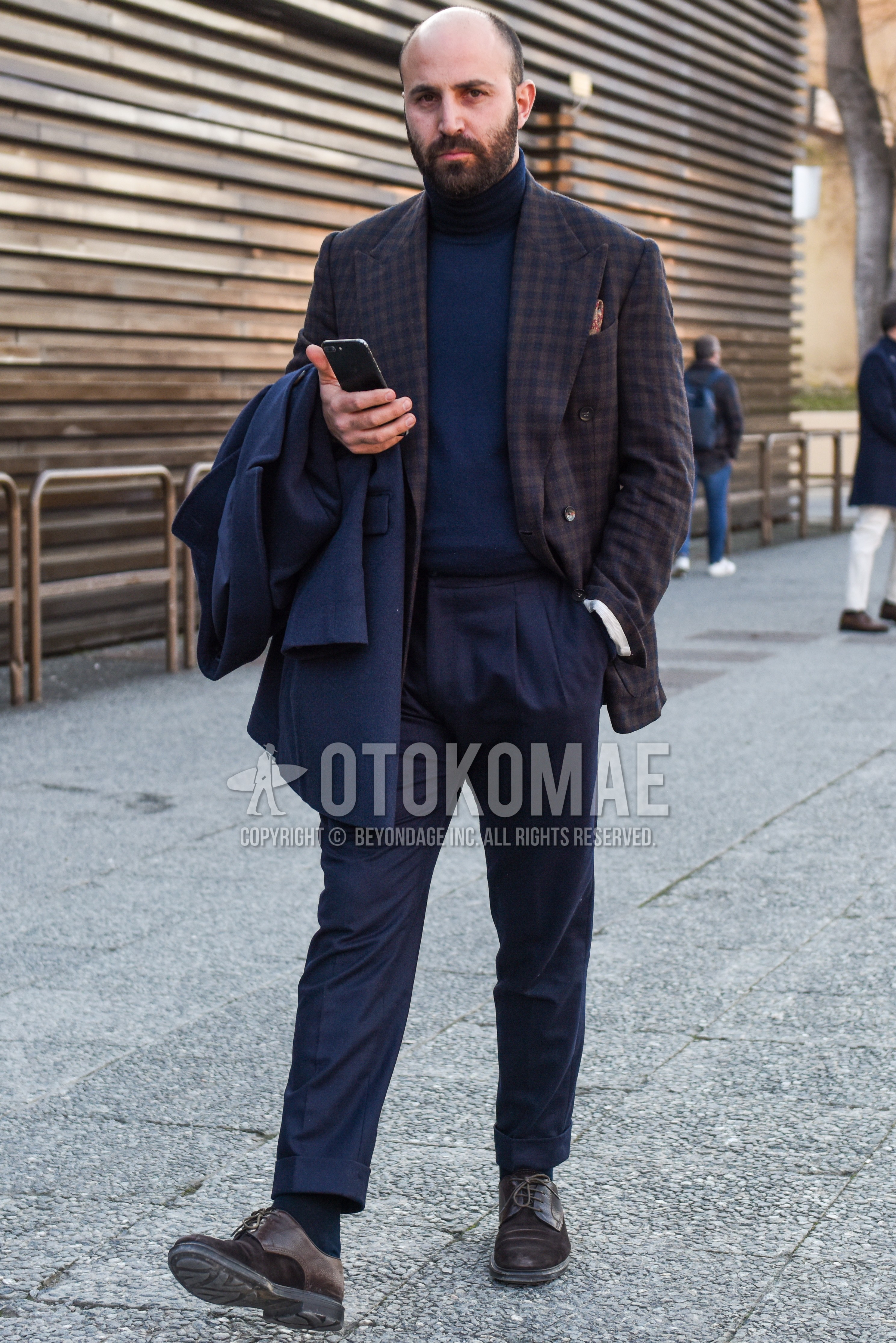 Men's spring autumn outfit with brown check tailored jacket, navy plain turtleneck knit, navy plain slacks, navy plain pleated pants, navy plain beltless pants, navy plain socks, brown plain toe leather shoes.