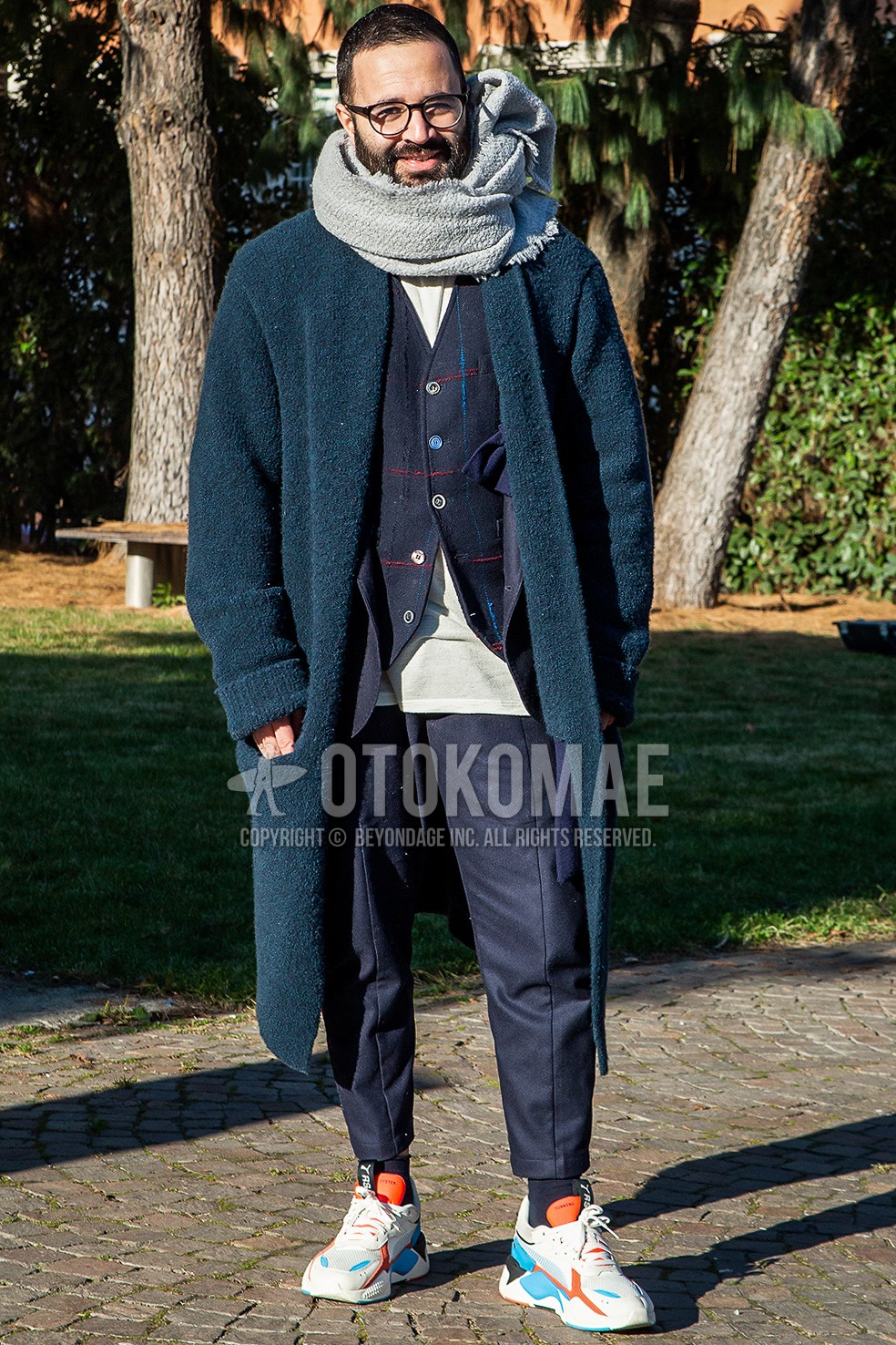 Men's winter outfit with plain glasses, gray plain scarf, navy check cardigan, white plain t-shirt, navy plain ankle pants, navy plain socks, white low-cut sneakers.